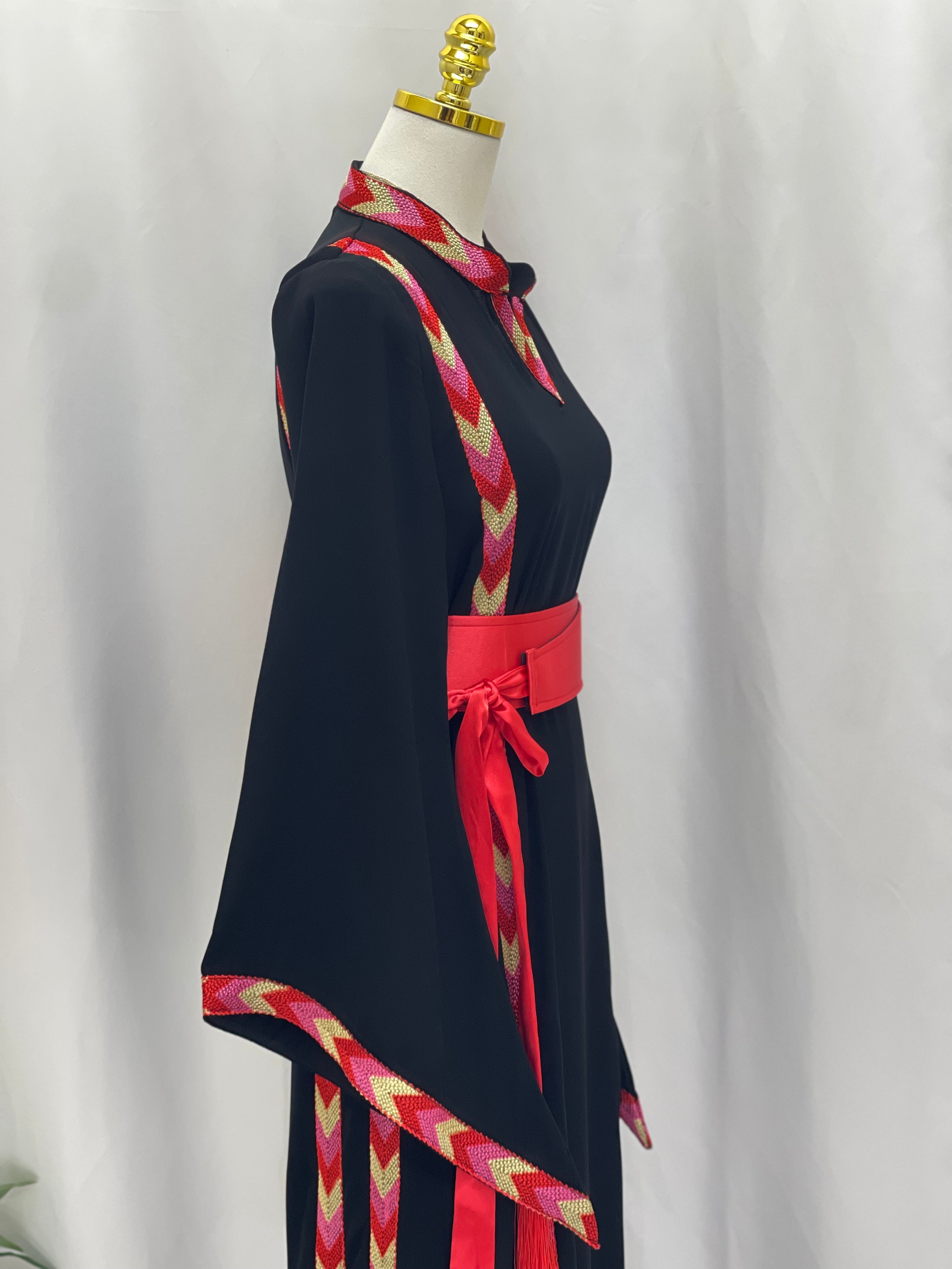Palestinian Elegance black embroidered thoub dress with colorful patterned trim and red waist belt