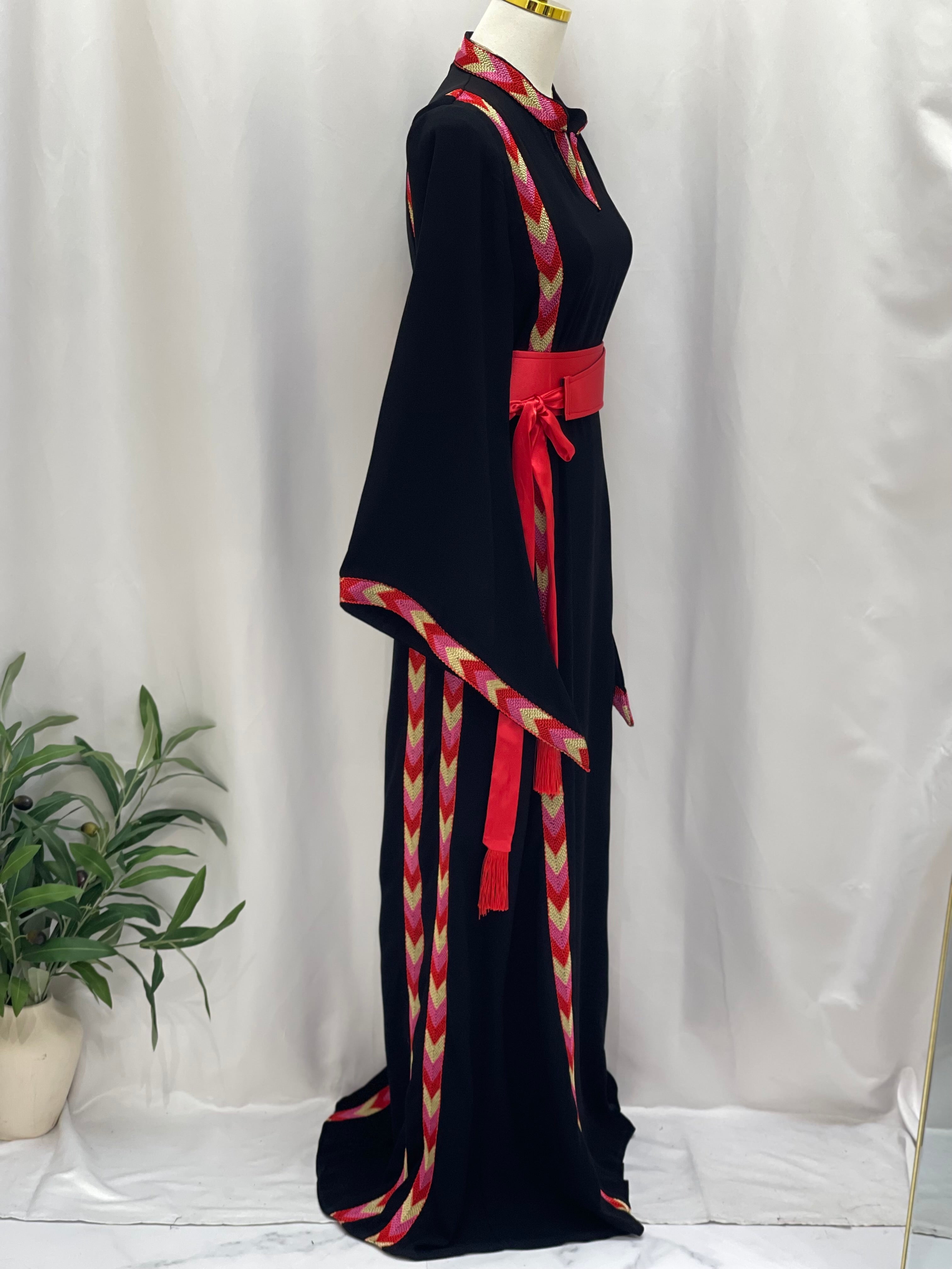 Palestinian Elegance black embroidered thoub dress with red and gold patterned trim and sash belt