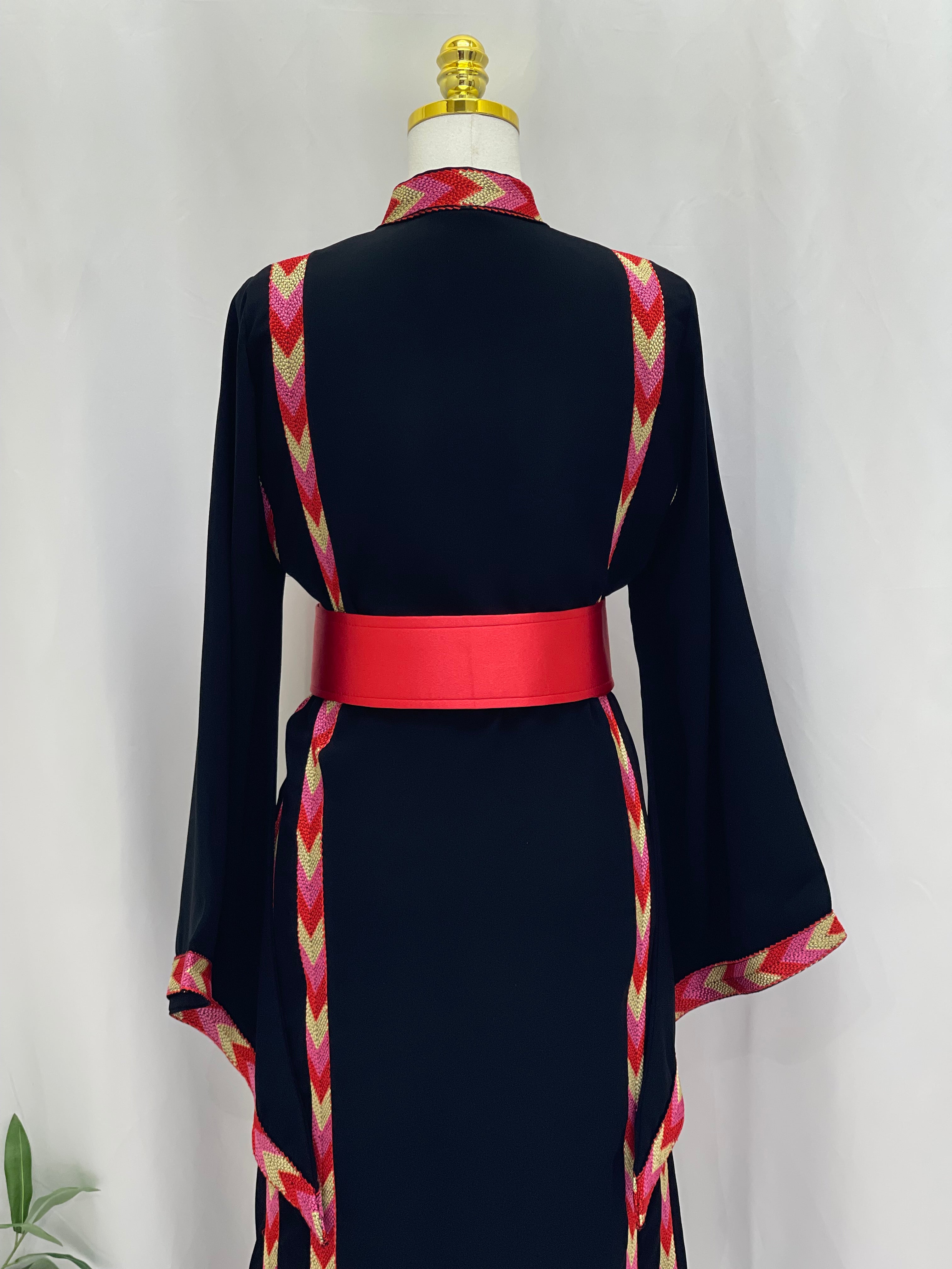 Palestinian Elegance embroidered thoub dress in black with red and pink geometric embroidery and a red belt