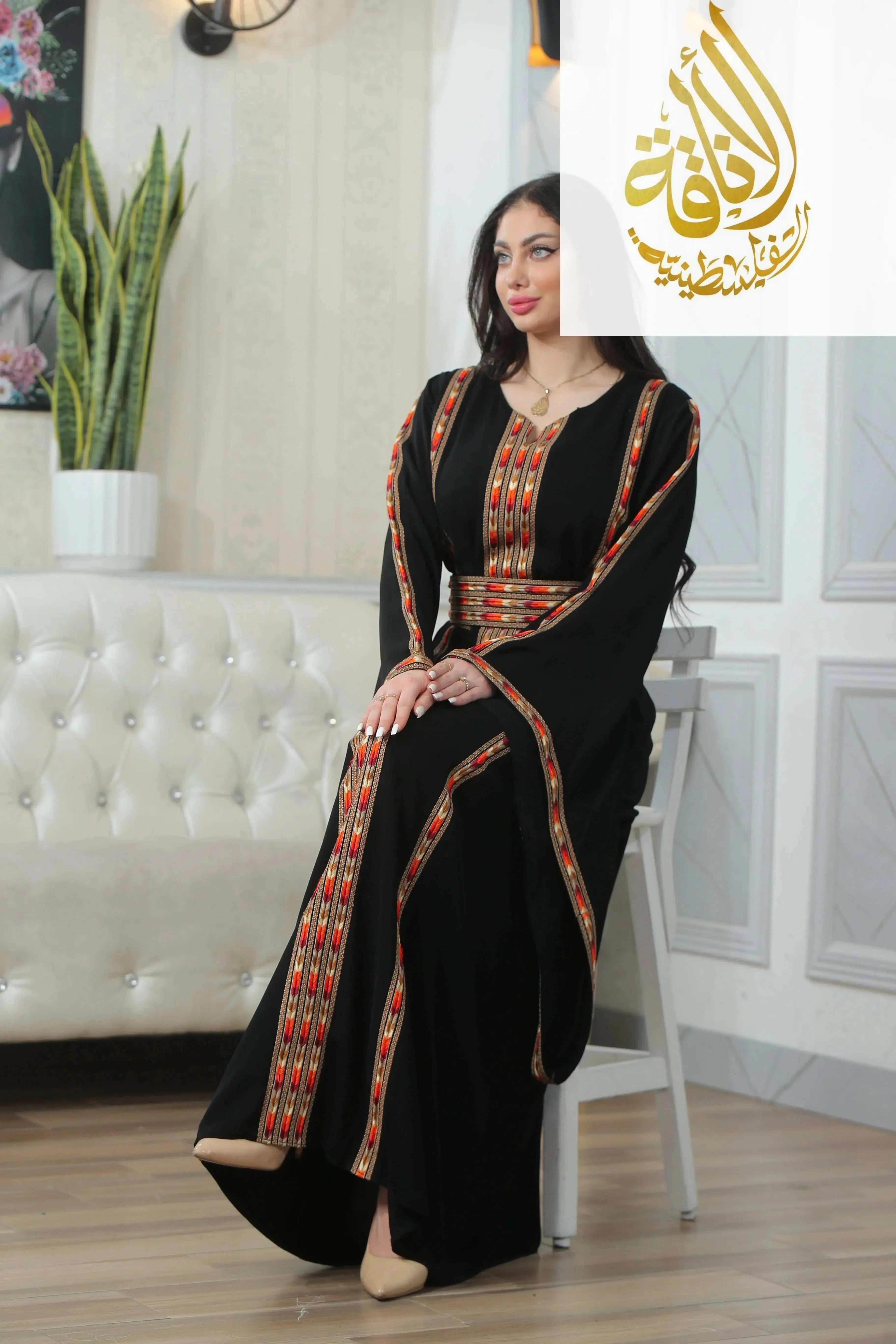 Palestinian Elegance woman wearing Salam Manjal Embroidered Thoub black traditional dress with red and gold embroidery
