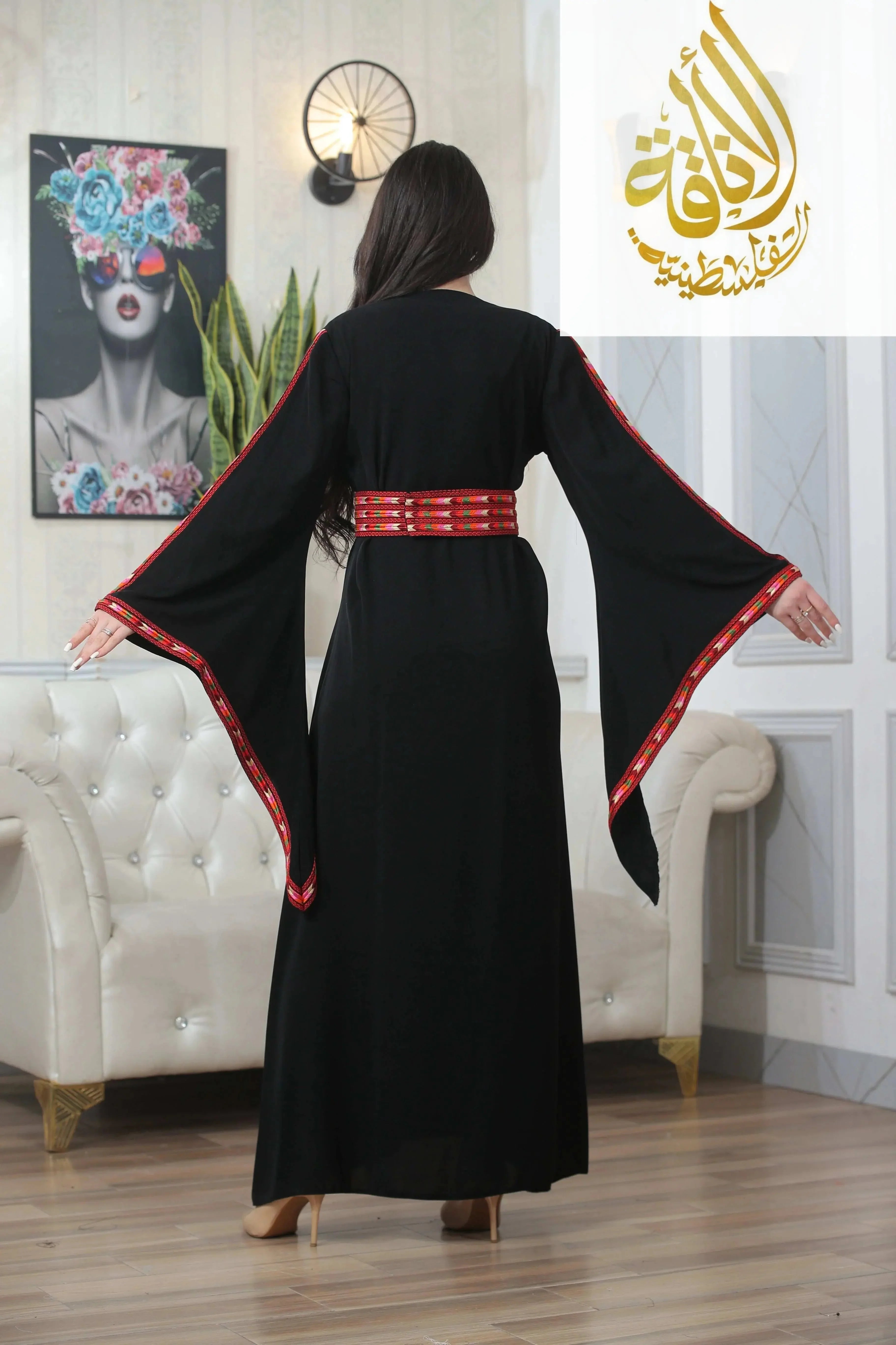 Back view of Salam Manjal Embroidered Thoub in black with red detailed embroidery on wide sleeves and waist belt