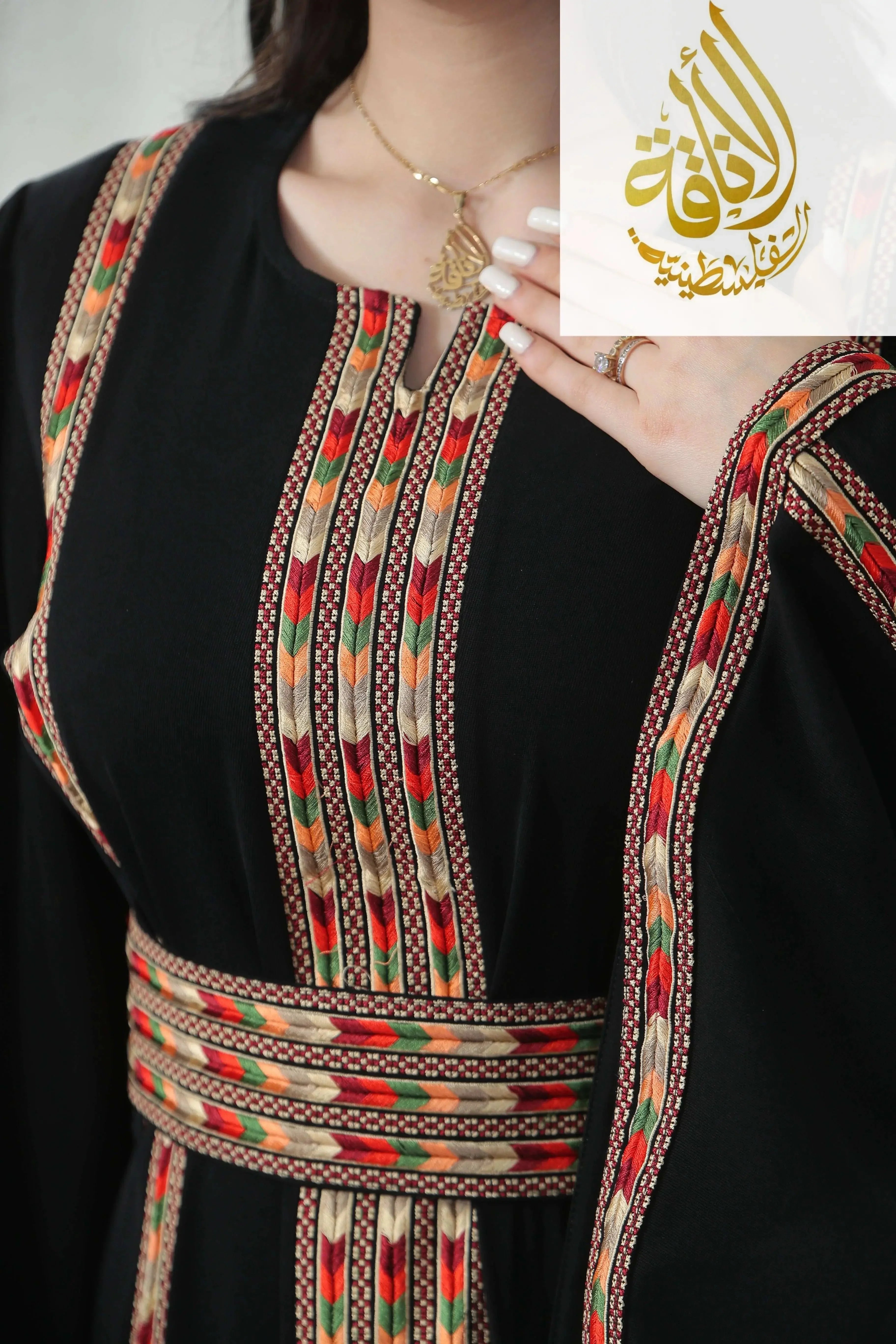 Palestinian Elegance Salam Manjal Embroidered Thoub with intricate colorful floral patterns on black fabric