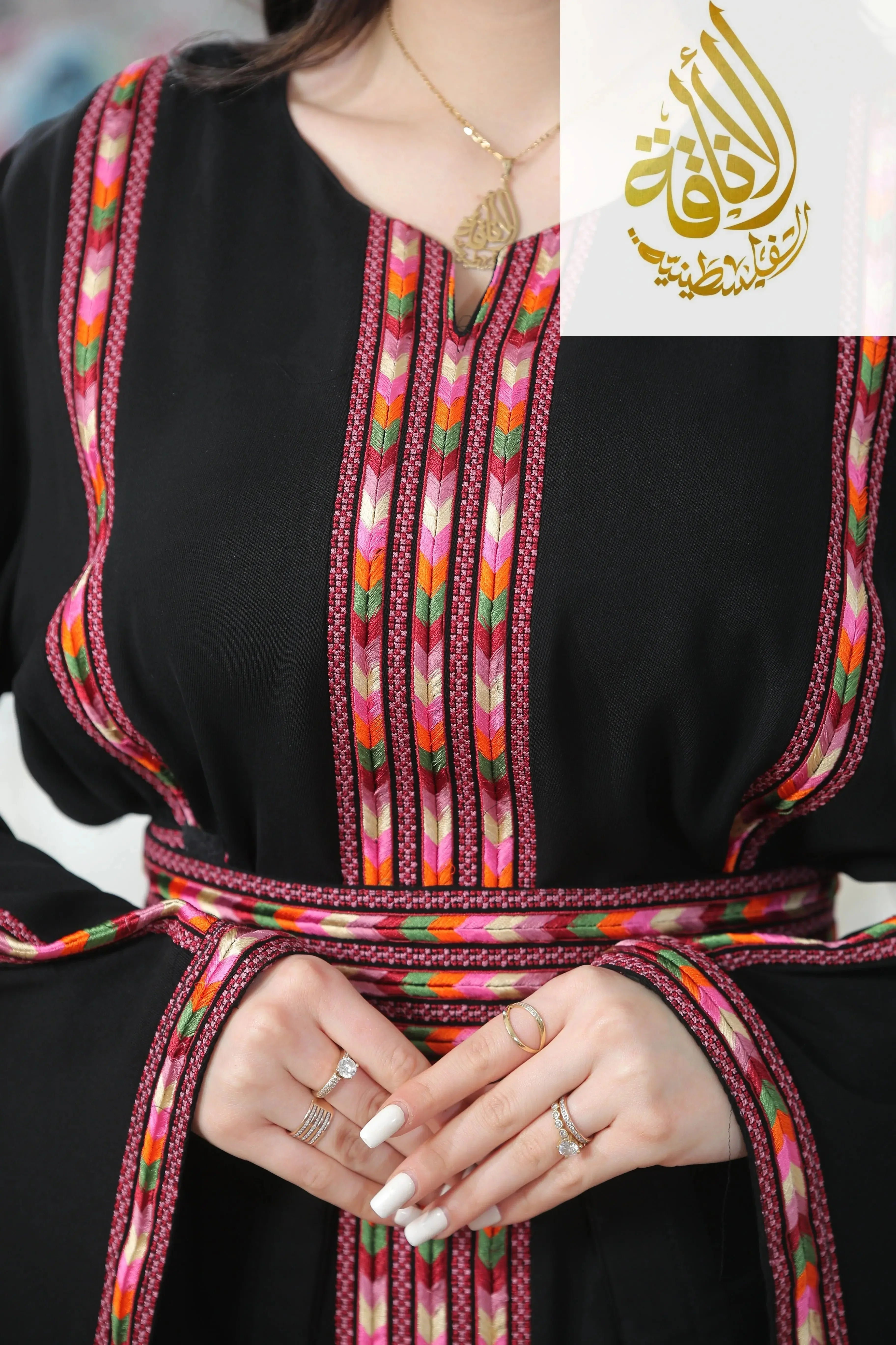 Palestinian Elegance Salam Manjal Embroidered Thoub in black with colorful intricate embroidery and matching belt
