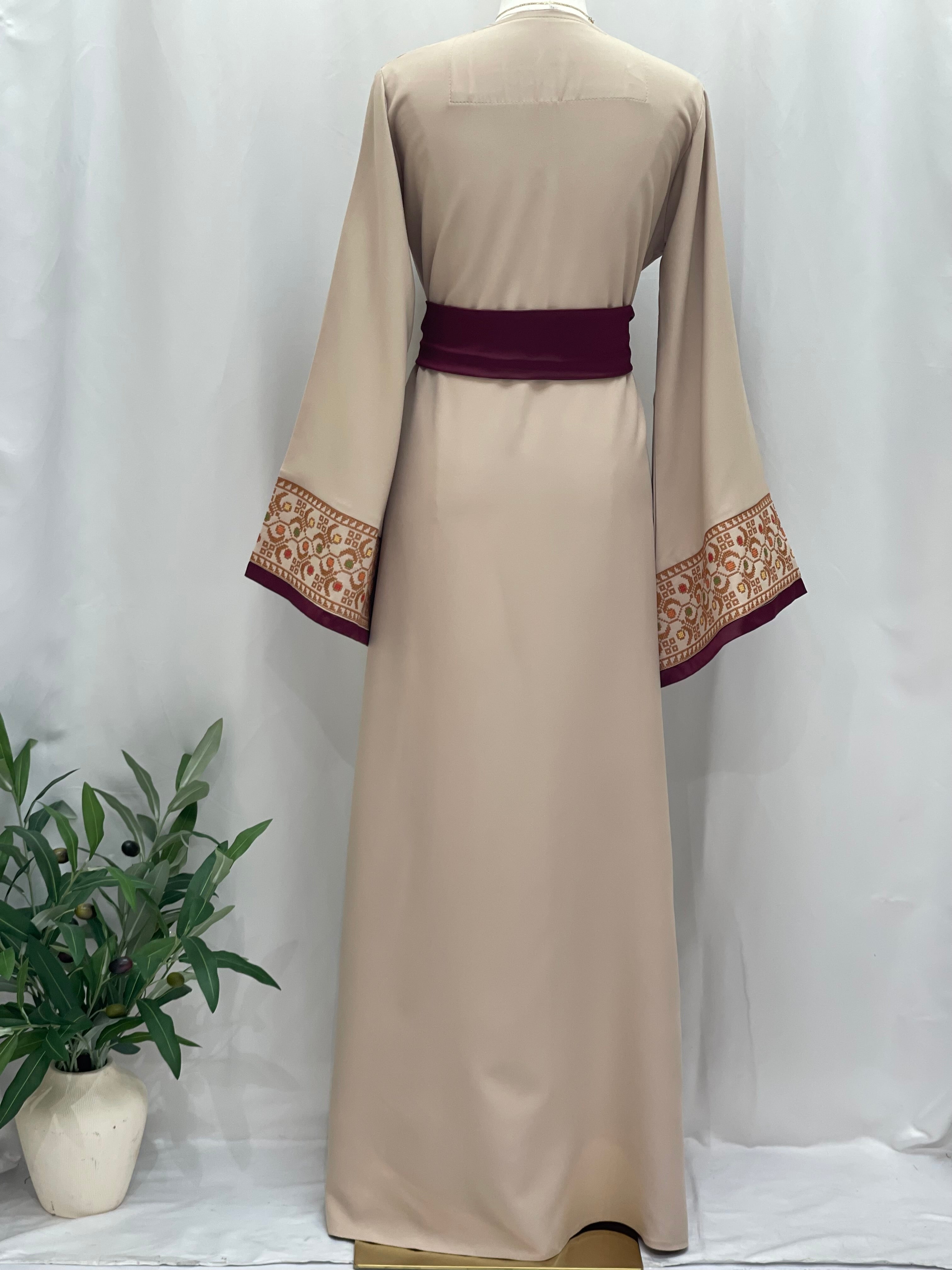 Beige Palestinian Elegance Embroiderd Thobe With Belt featuring detailed sleeve embroidery and maroon waist belt