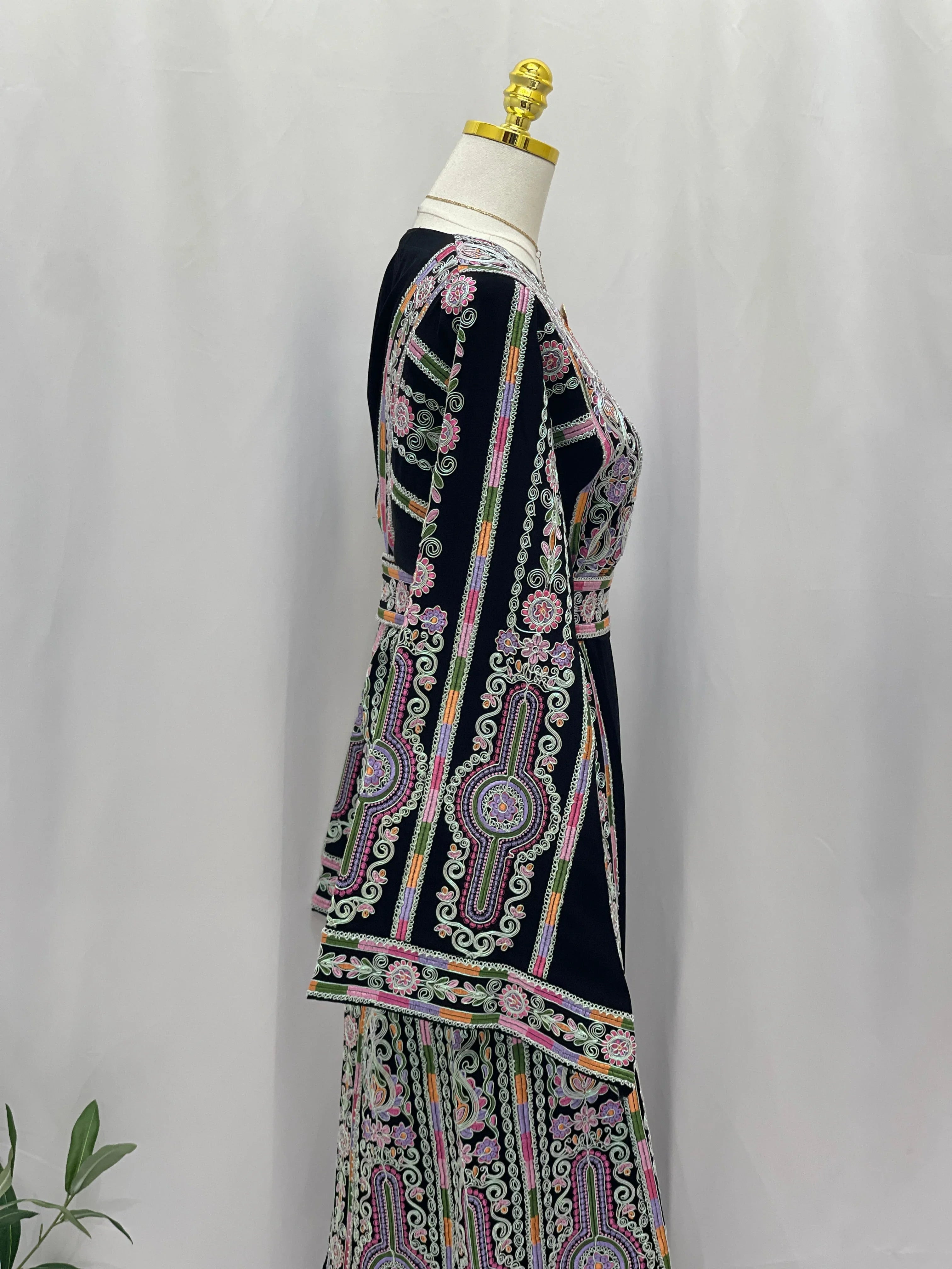 Palestinian Elegance Silver Piping Embroidered Thobe side view on mannequin with black base and colorful floral embroidery
