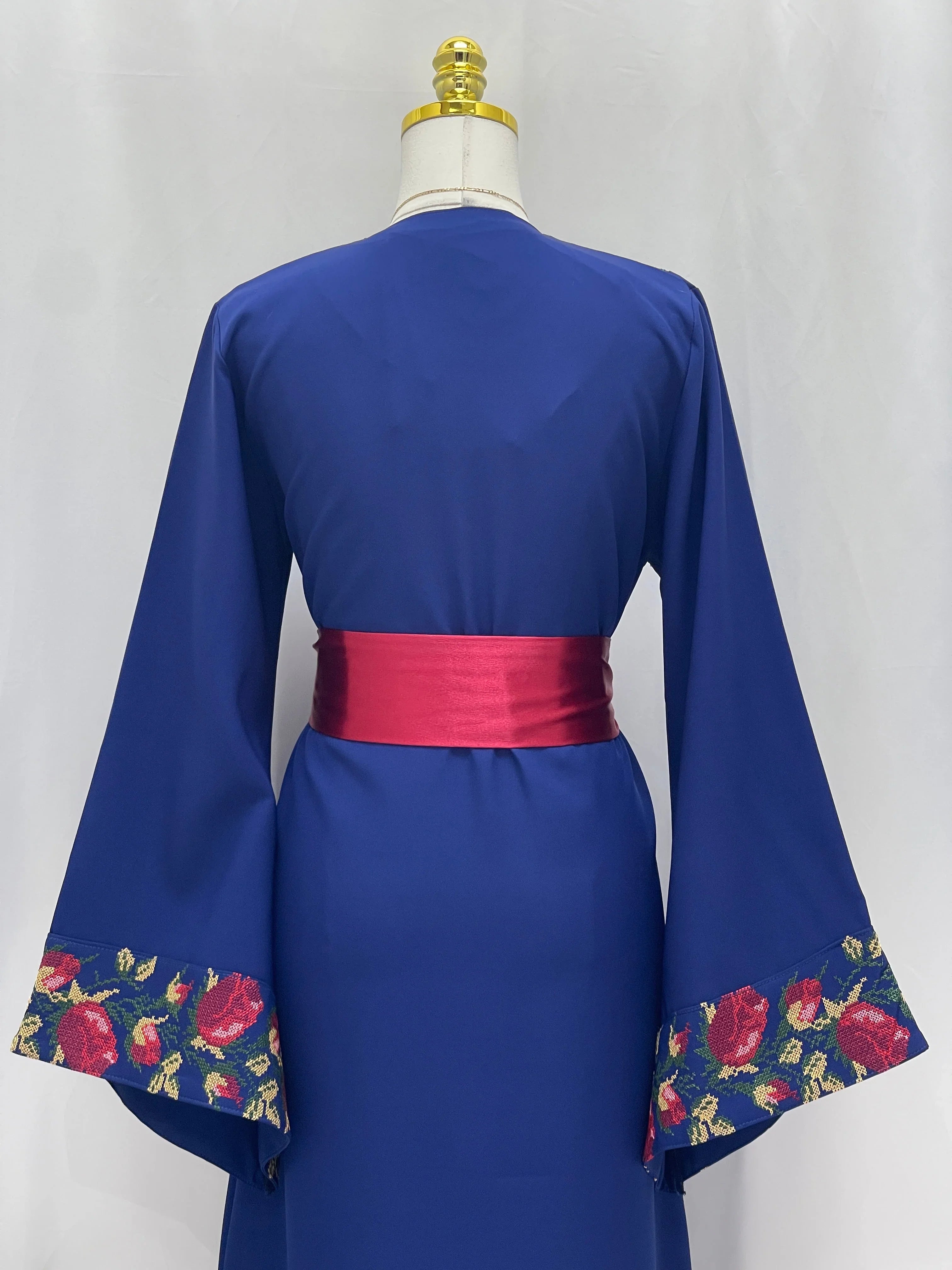 Back view Blossom Royal Blue Thobe with embroidered floral sleeve trim and fuchsia waist sash