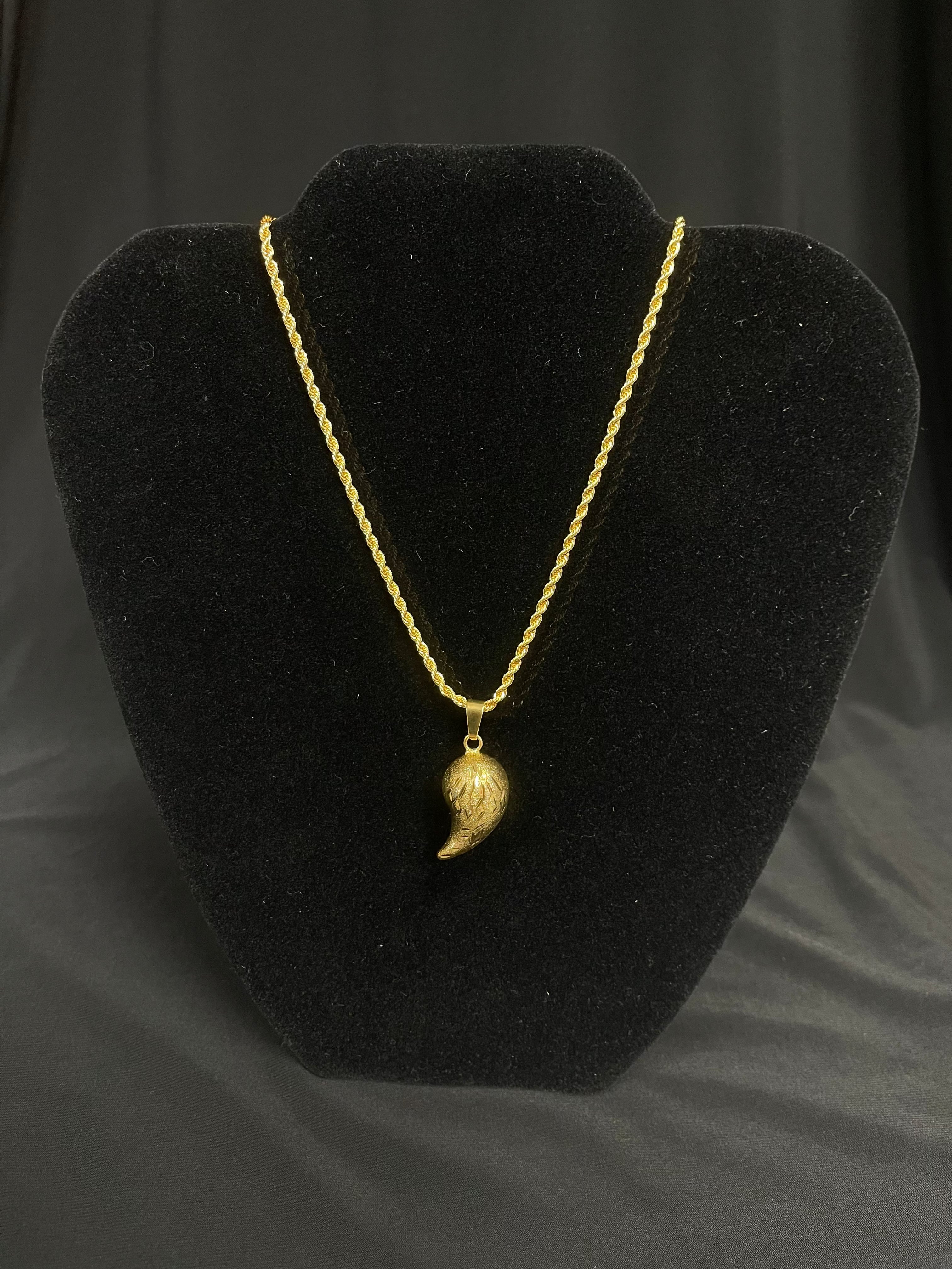 Almond shape gold pendant necklace on black display by Palestinian Elegance imitated gold jewelry