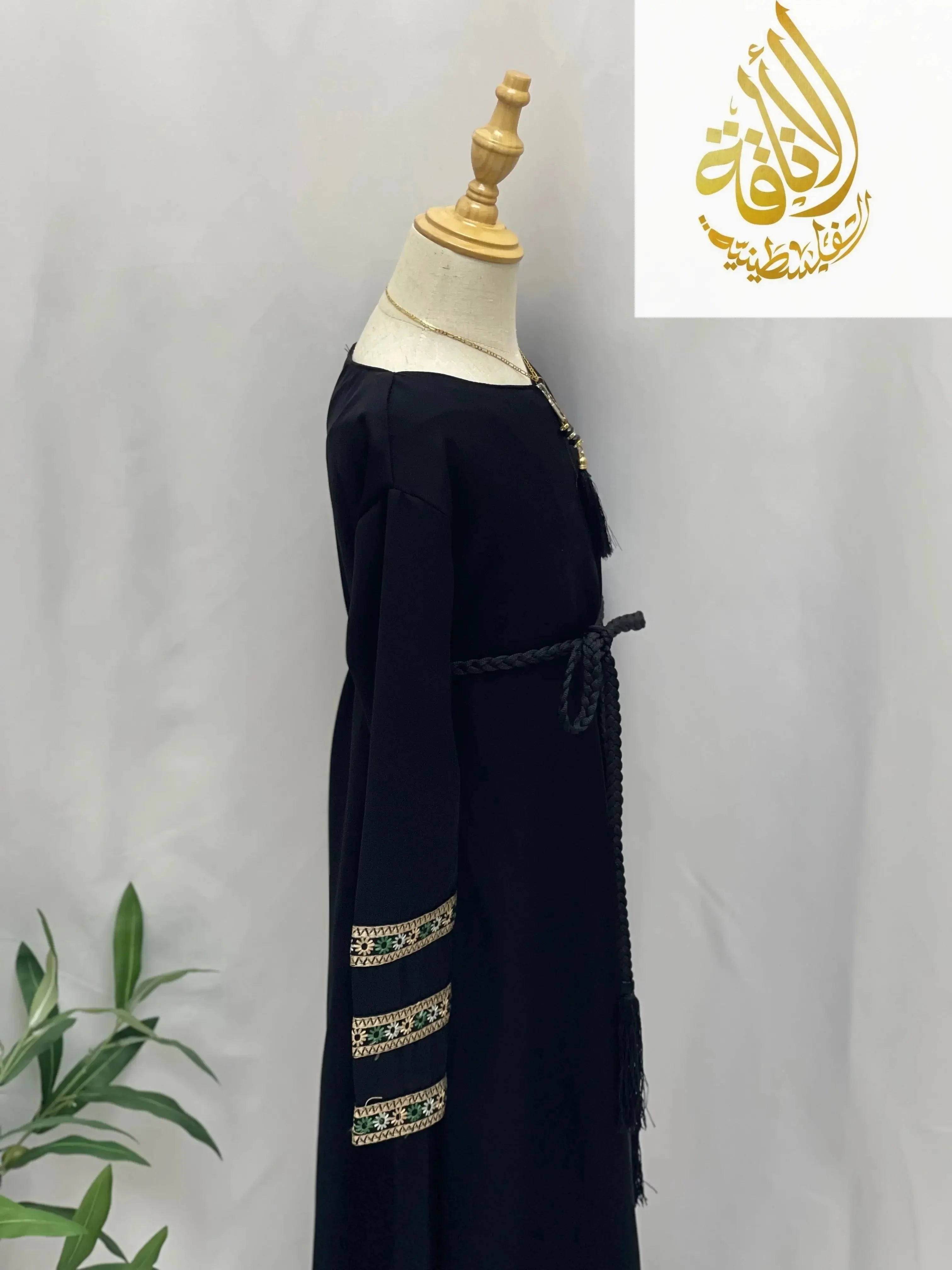 Black embroidered abaya for girls with detailed sleeve patterns and braided waist belt by Palestinian Elegance