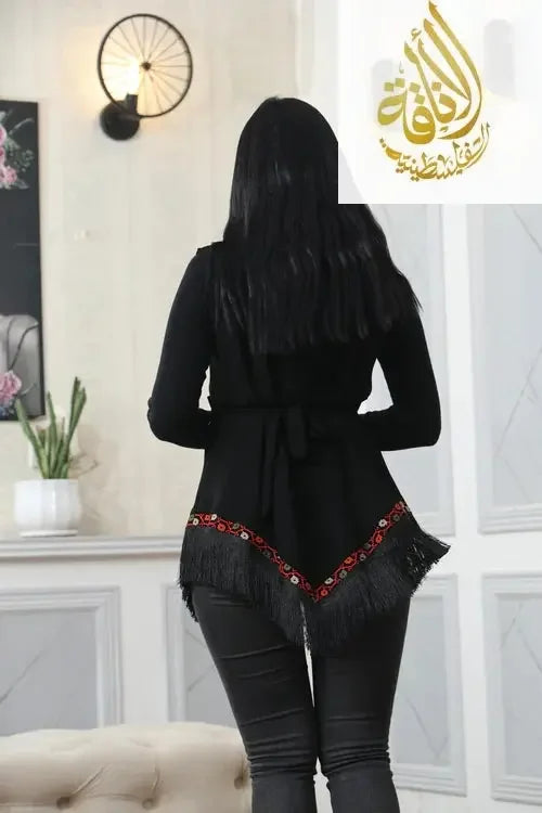 Back view of black embroidered vest with fringe detail worn over black outfit by Palestinian Elegance