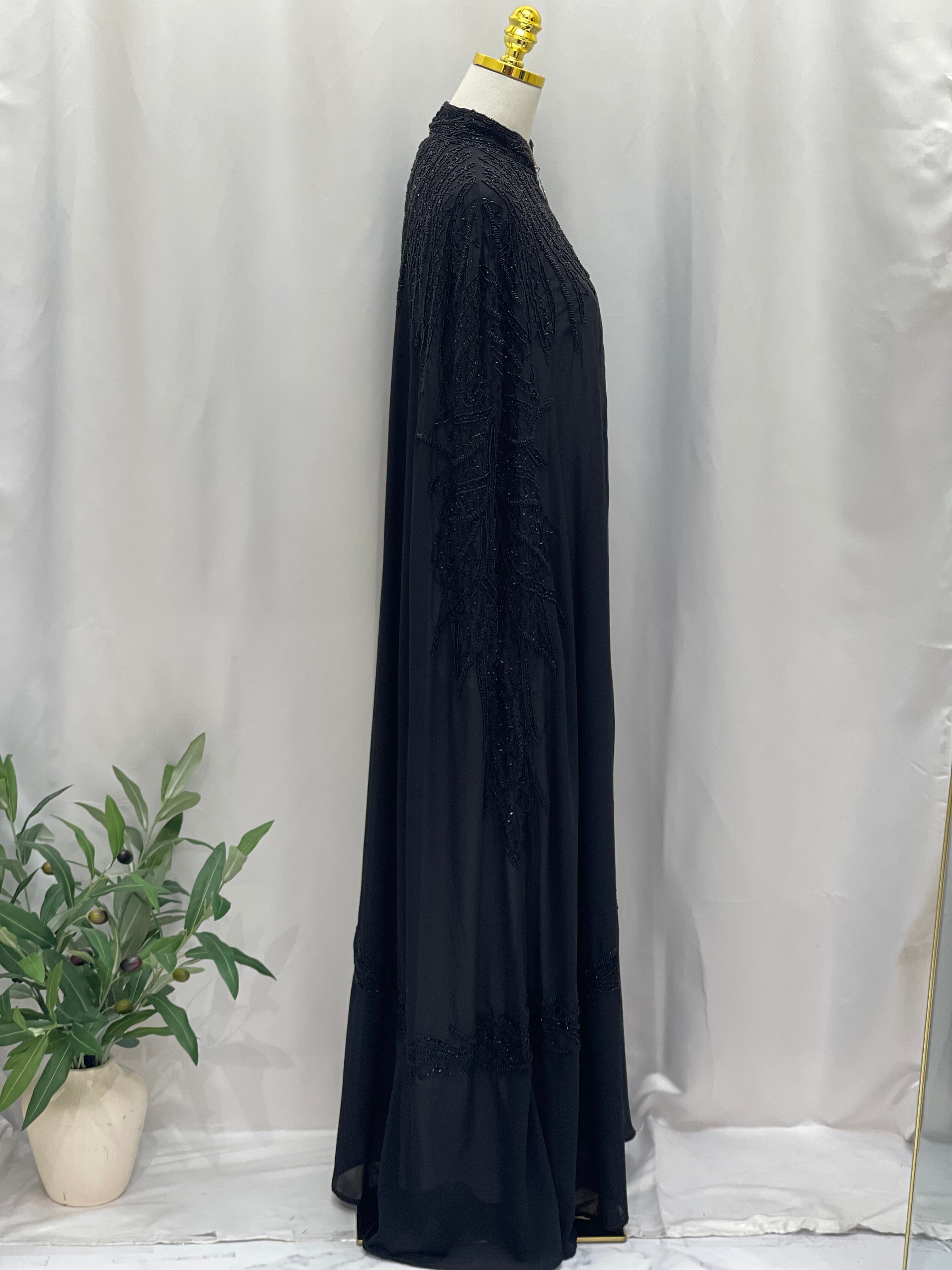 Black traditional embroidery cape with intricate stitched details displayed on mannequin