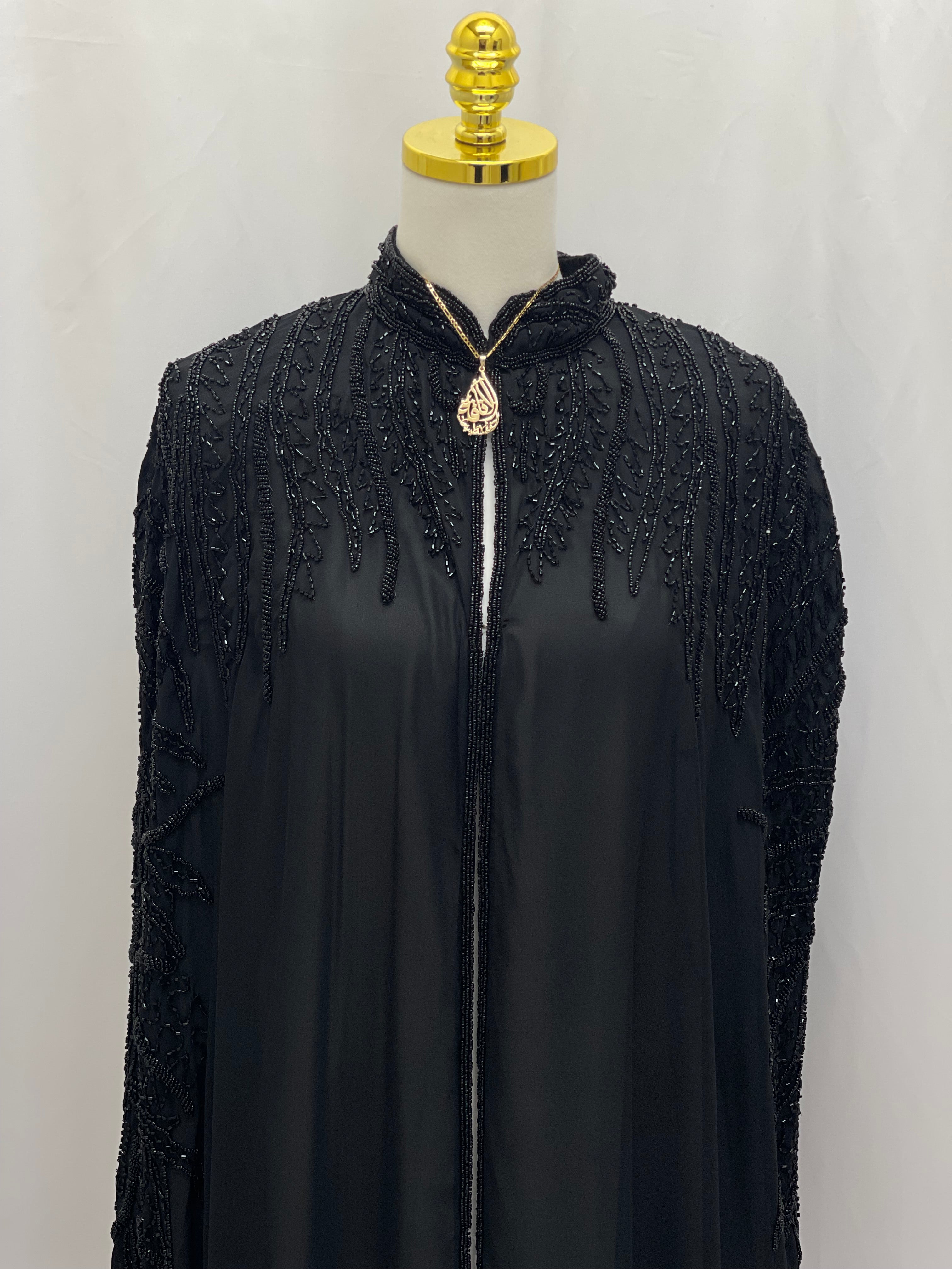 Black traditional embroidery cape by Palestinian Elegance with intricate beadwork on shoulders and neckline