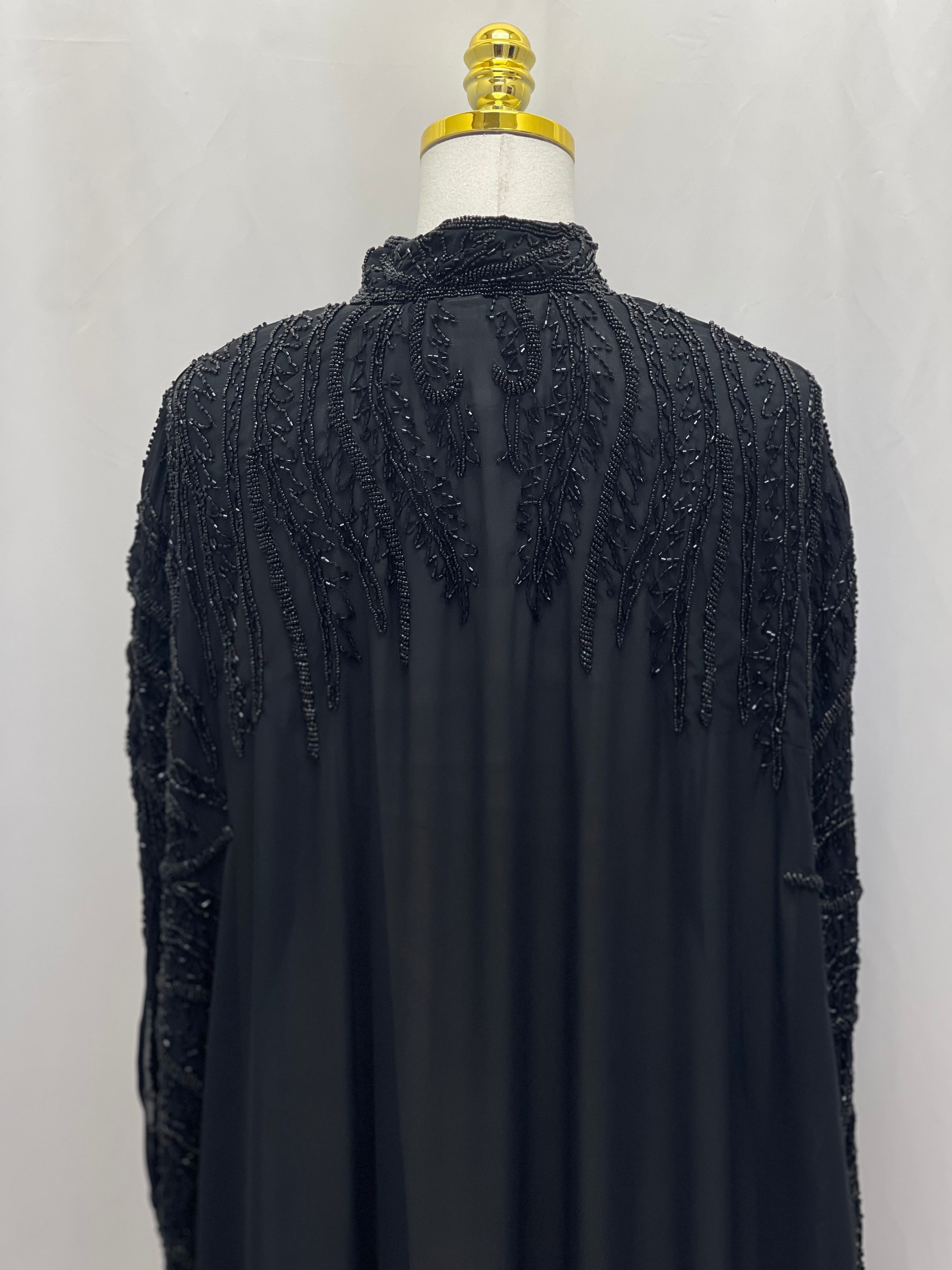 Black traditional embroidery cape with intricate beadwork on shoulders and sleeves by Palestinian Elegance