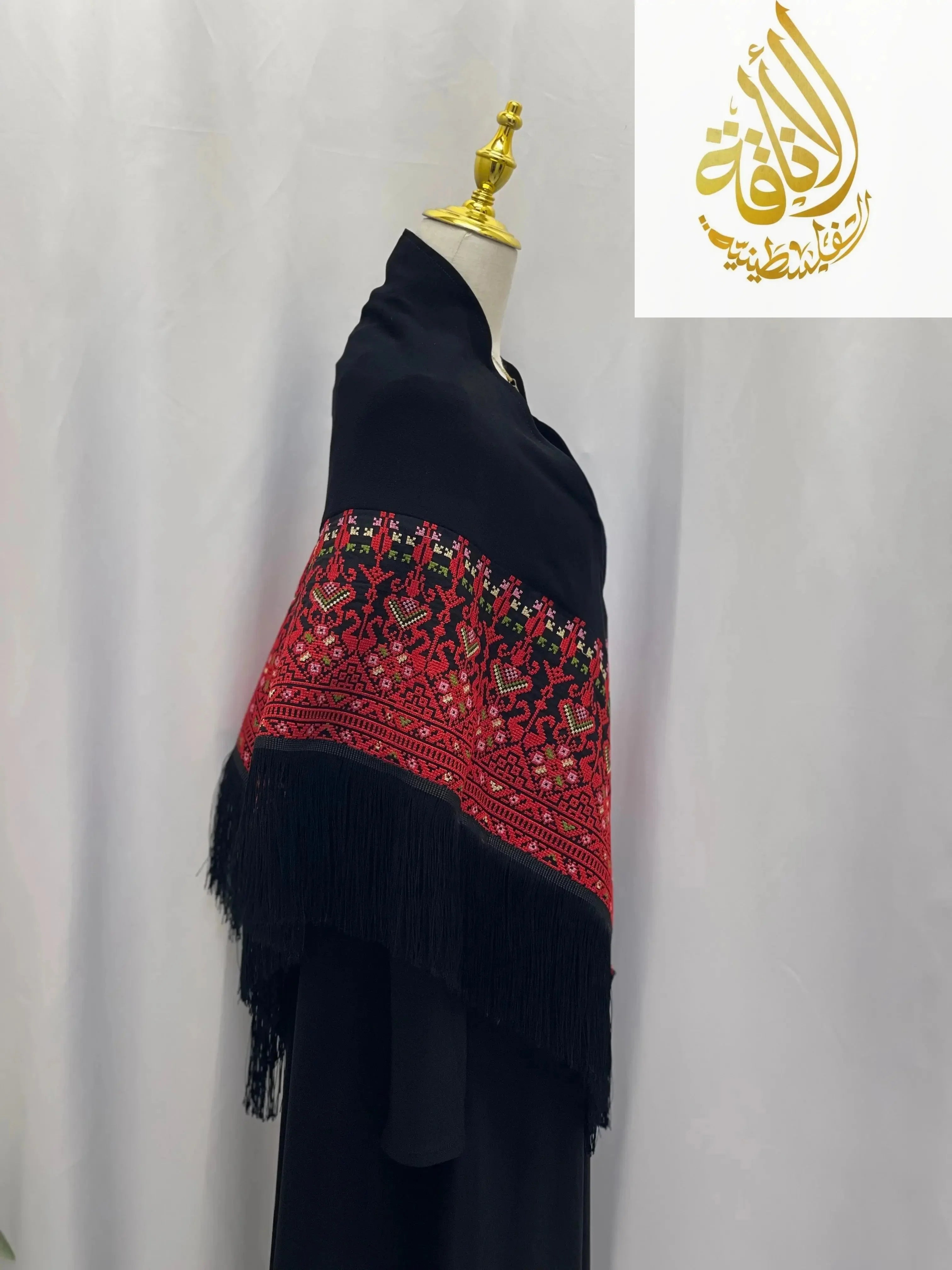 Palestinian embroidered shawl with intricate red and green embroidery on black fabric from Palestinian Elegance
