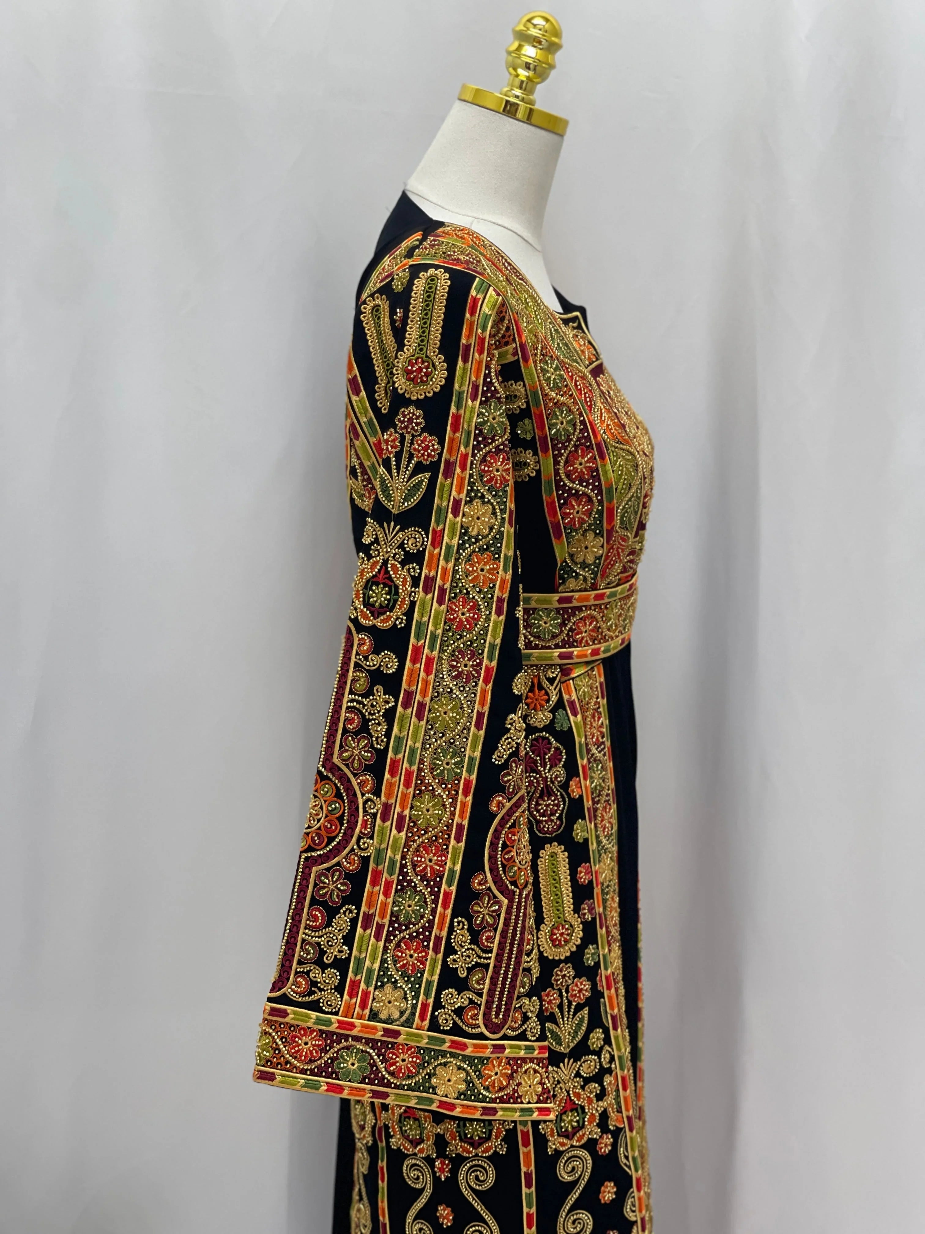 Palestinian Thoub with Beaded Embroidery on black dress side view featuring red gold green intricate floral panels