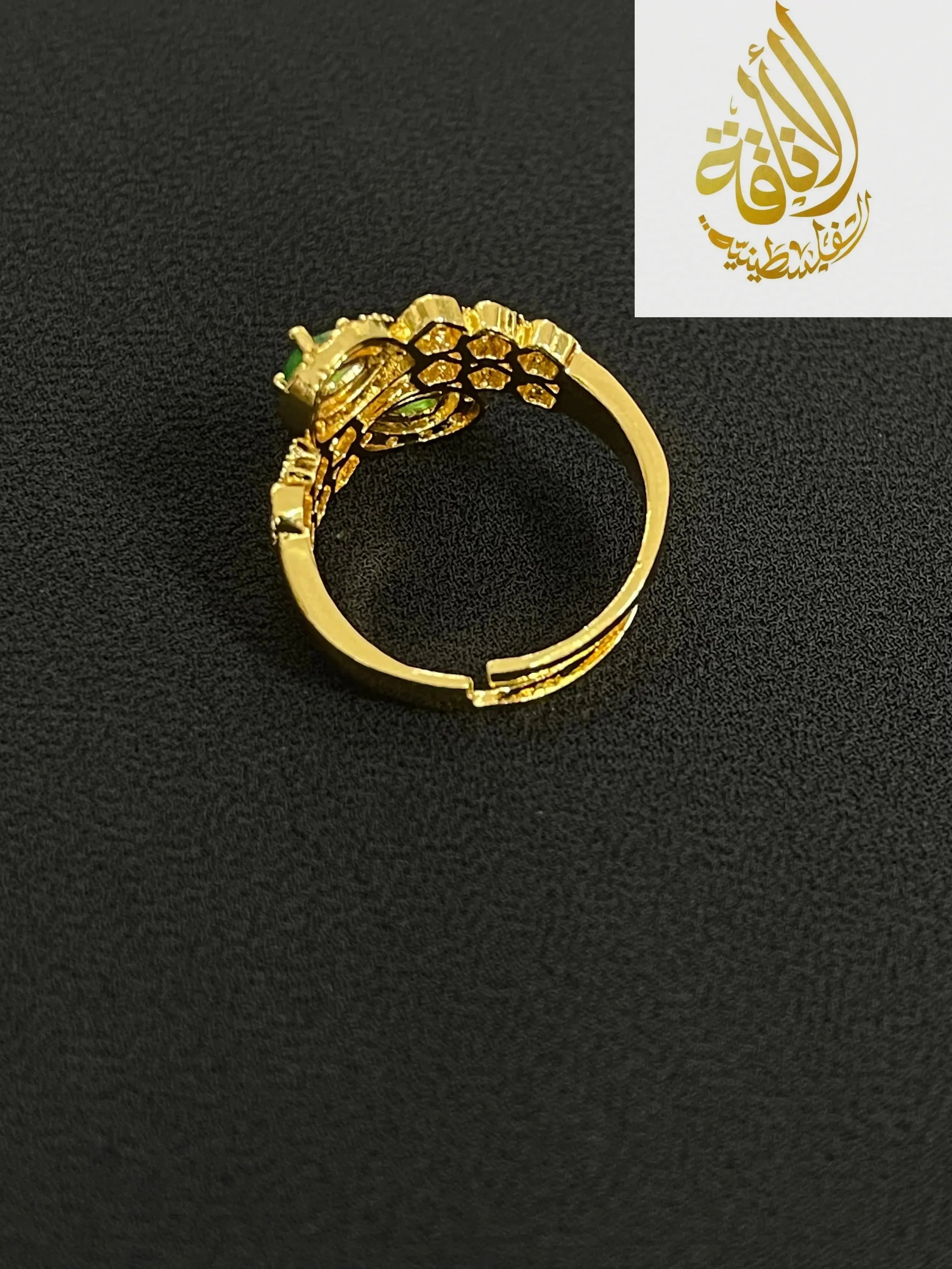 Gold adjustable ring from Palestinian gold jewelry set with intricate floral design and green stone accents