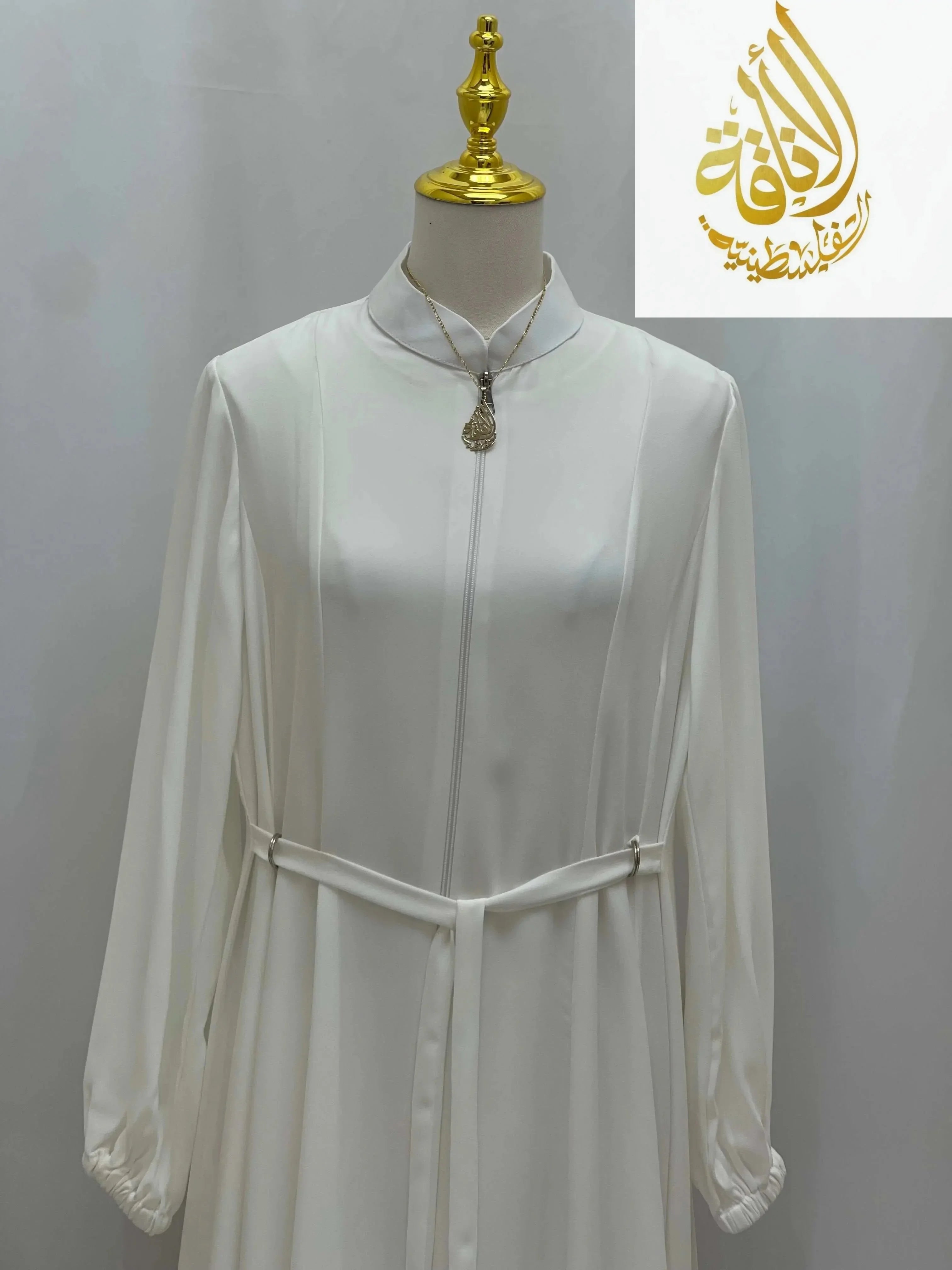 White Umra and Hajj Abaya by Palestinian Elegance with long sleeves and waist belt on mannequin