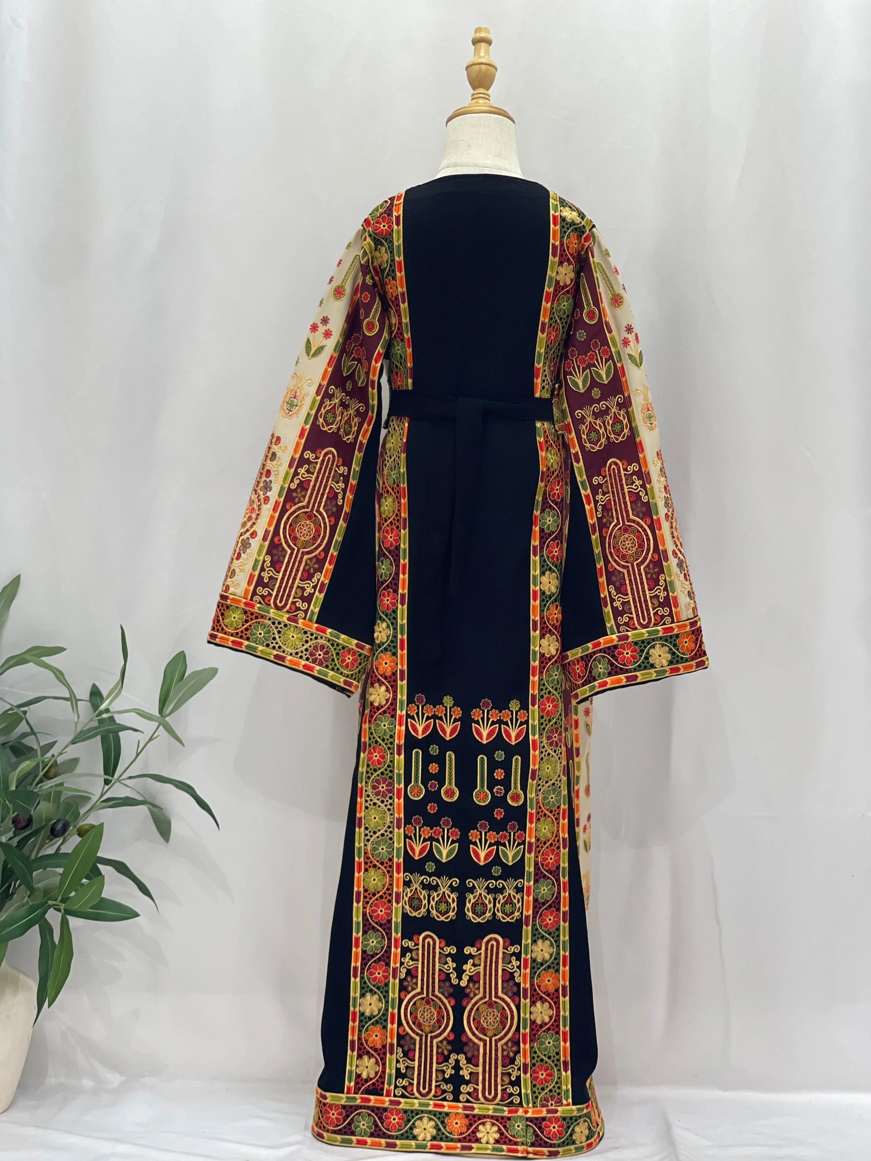 Back view of an Embroidered Girls Thoub featuring vibrant traditional patterns and flowing sleeves