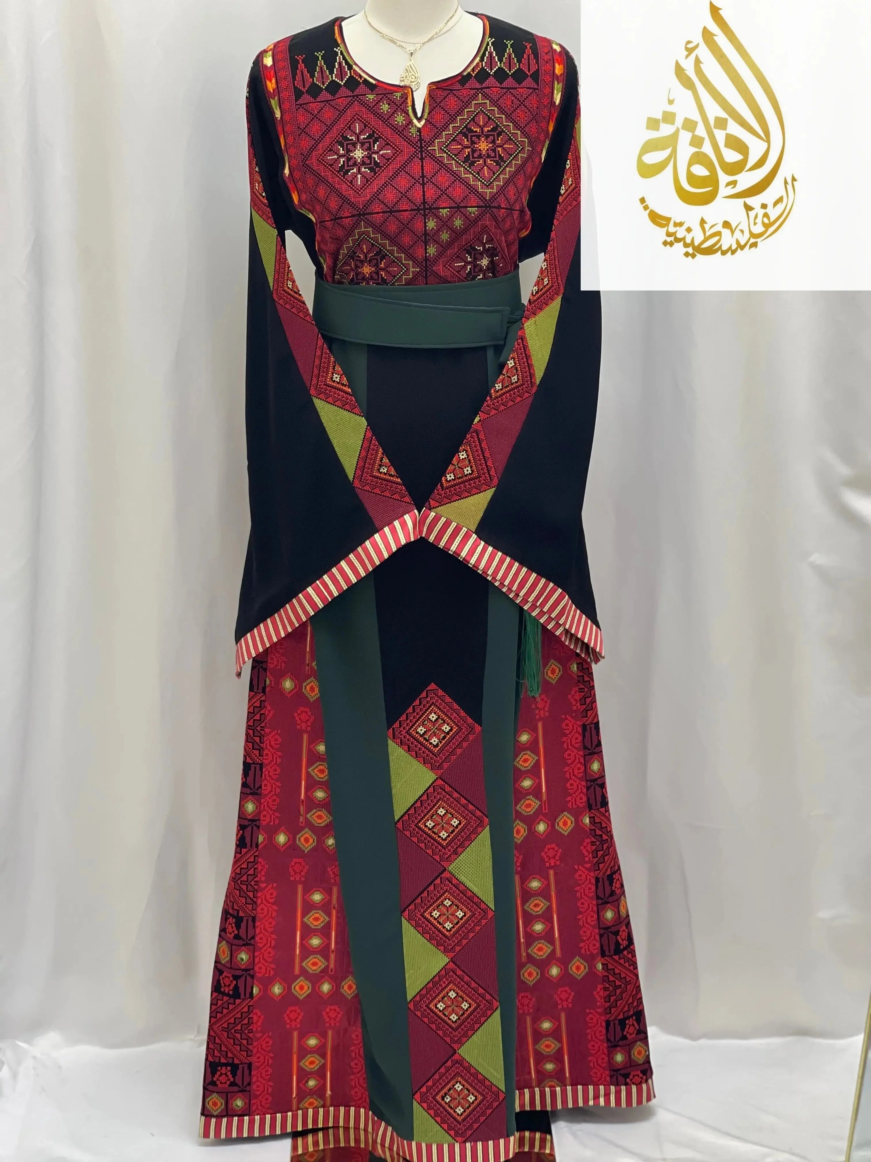 Embroidered Palestinian thoub by Palestinian Elegance featuring traditional red and black geometric patterns with green accents