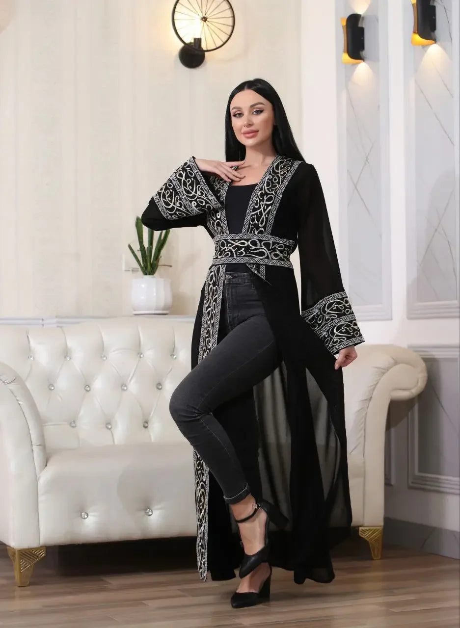 Black Arabic letter embroidered cardigan with intricate silver embroidery worn over black outfit by a model