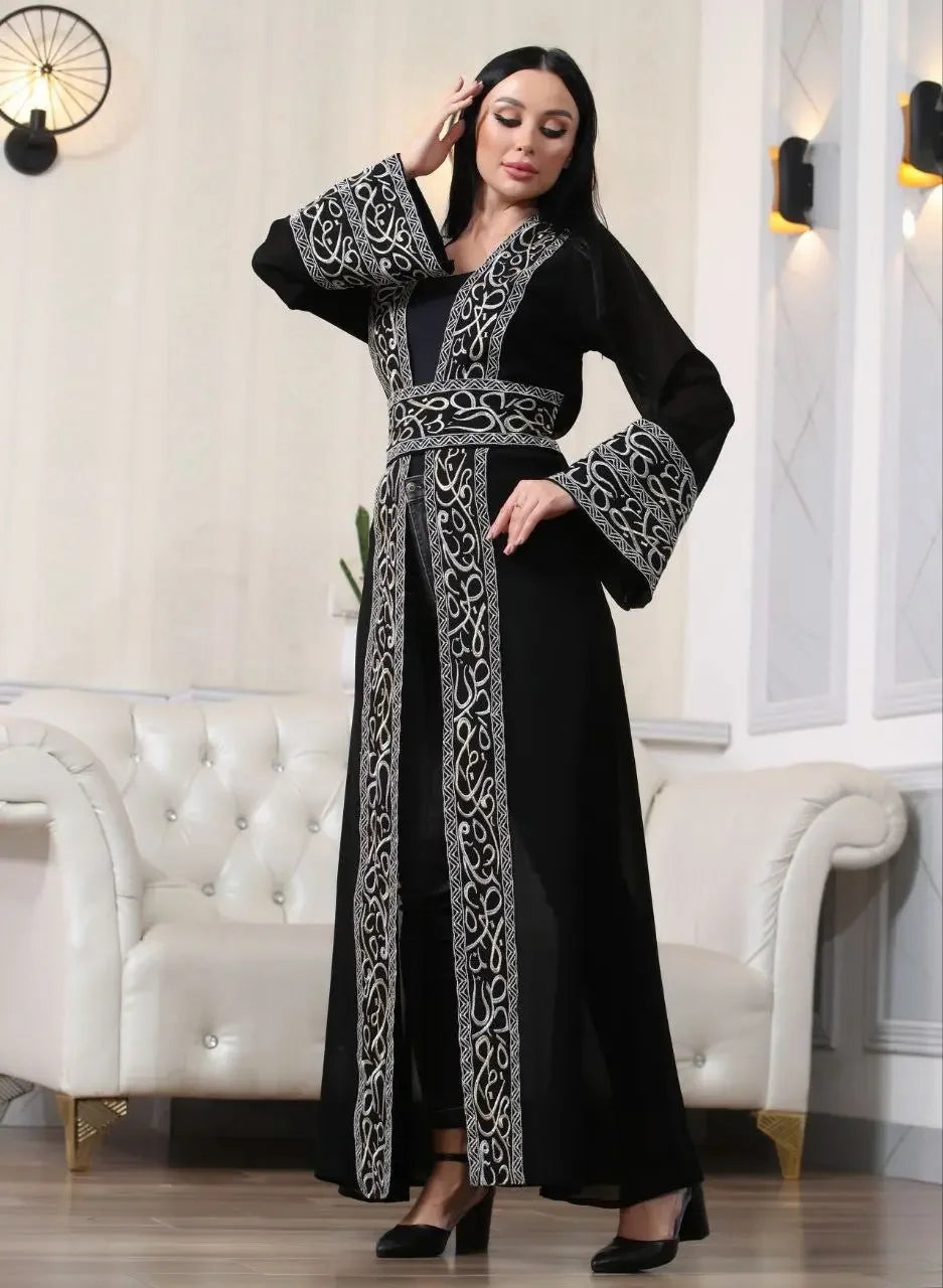 Woman wearing a black Arabic letter embroidered cardigan with intricate silver embroidery and wide sleeves