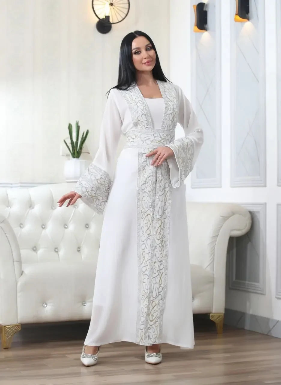 Elegant white Arabic letter embroidered cardigan with intricate designs worn by model in a stylish living room