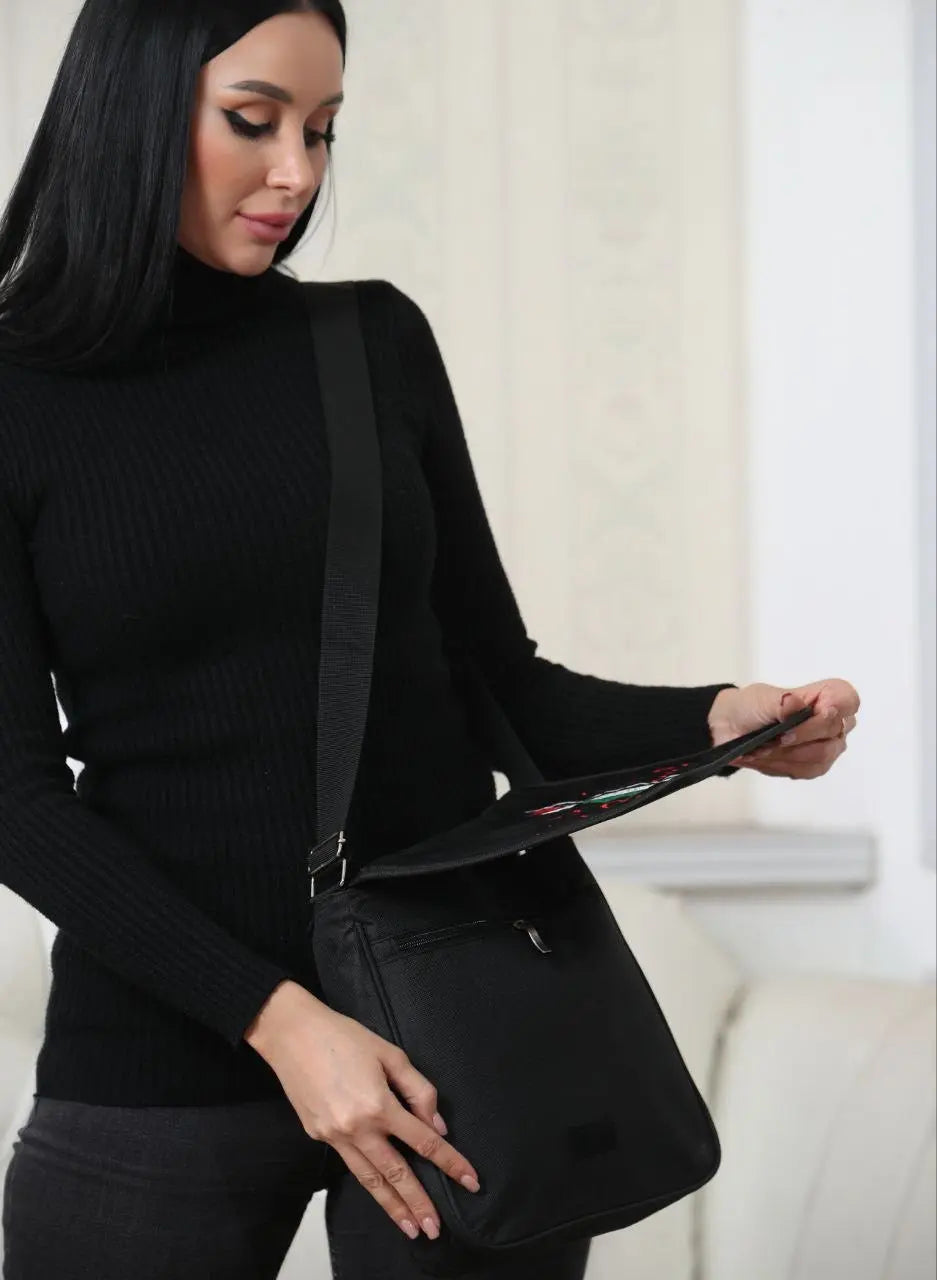 Woman wearing a black outfit carrying an embroidered Palestine shoulder bag with adjustable strap