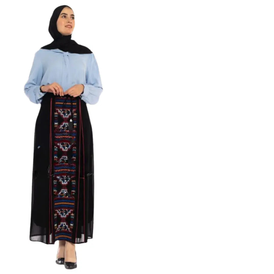 Woman wearing a Palestinian Elegance embroidered skirt with traditional colorful patterns and a black headscarf