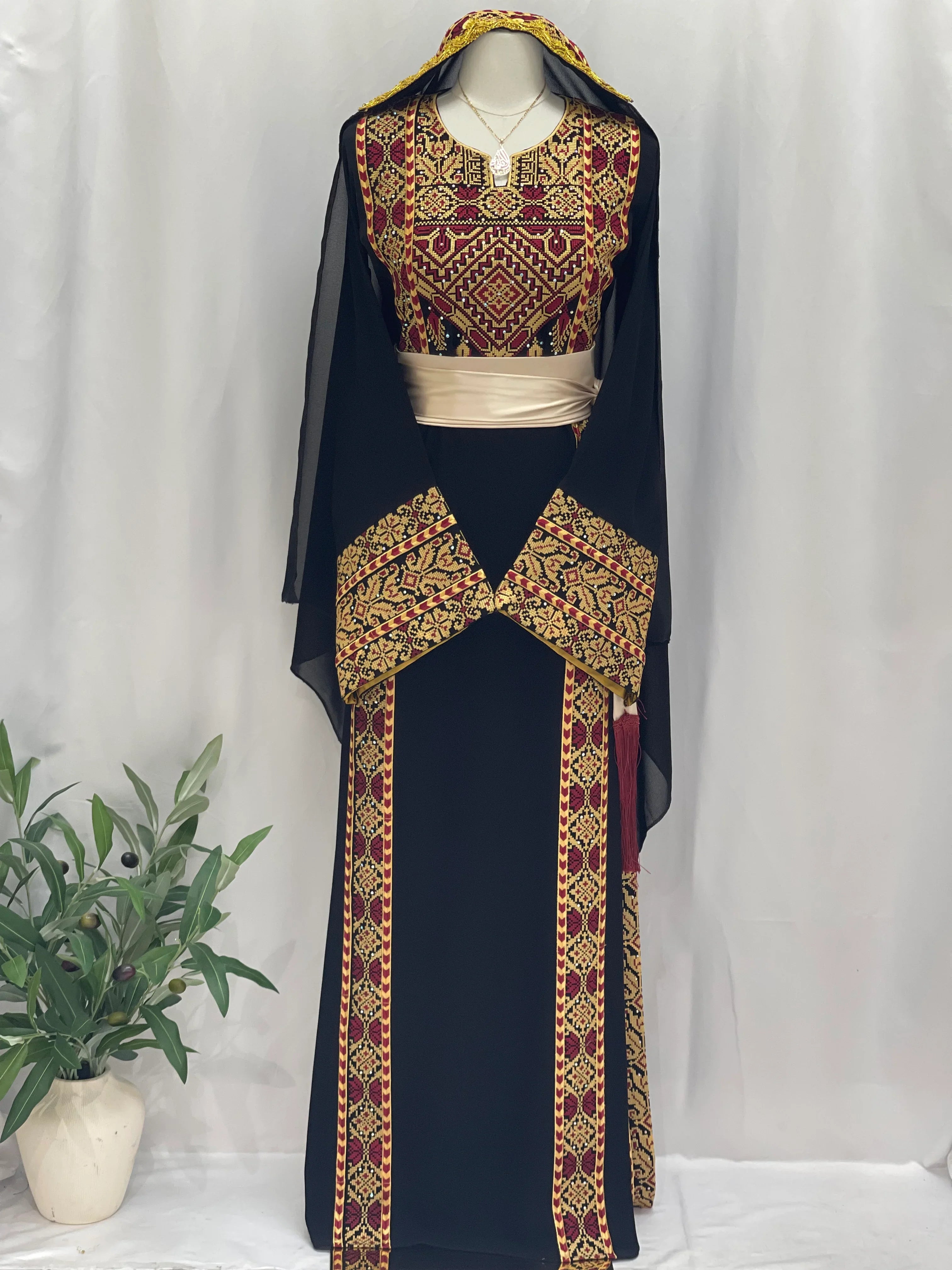 Palestinian embroidered thoub with intricate red and gold embroidery on black fabric featuring a matching hood