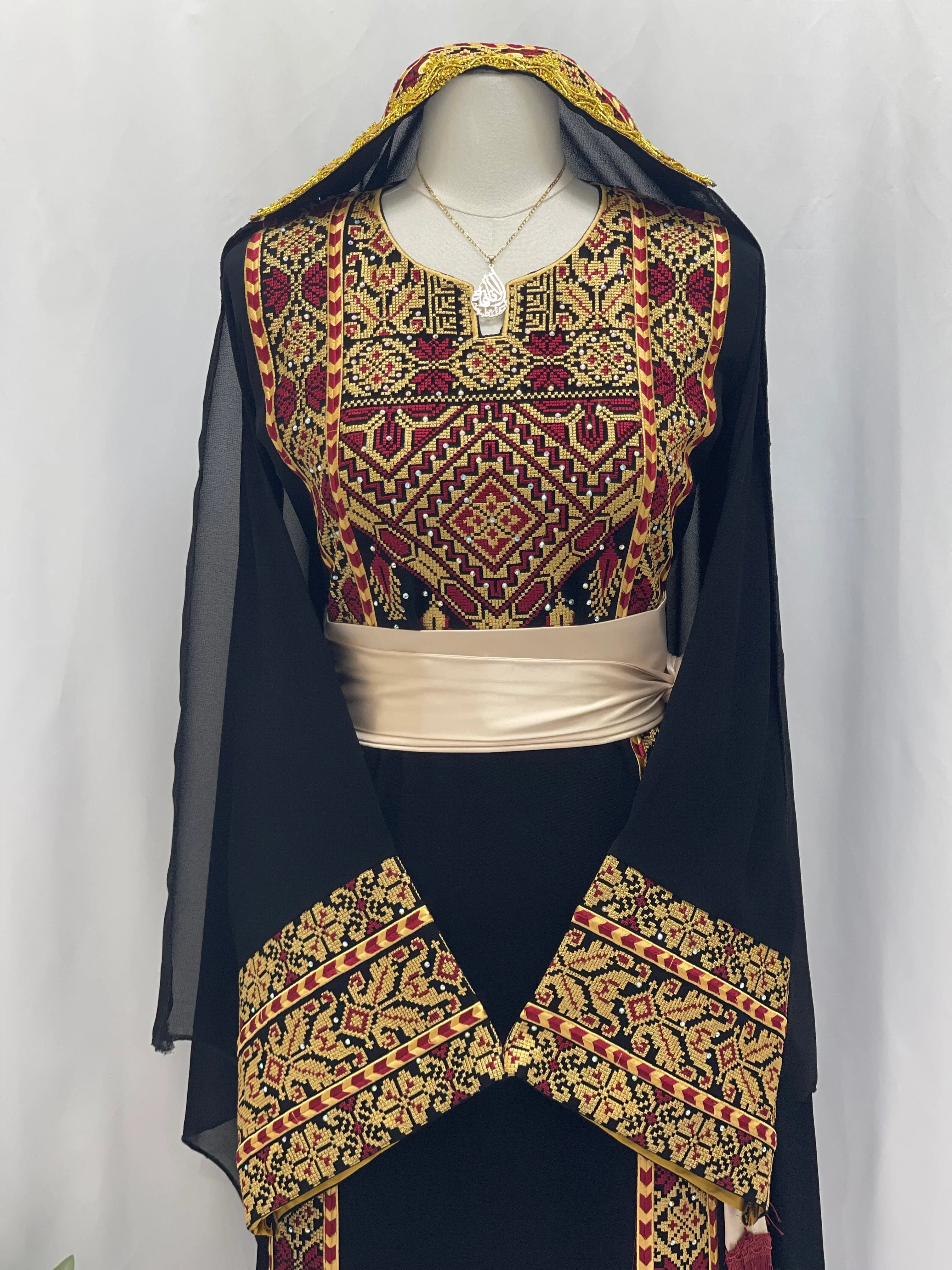 Palestinian embroidered thoub by Palestinian Elegance featuring intricate red and gold embroidery on black fabric 