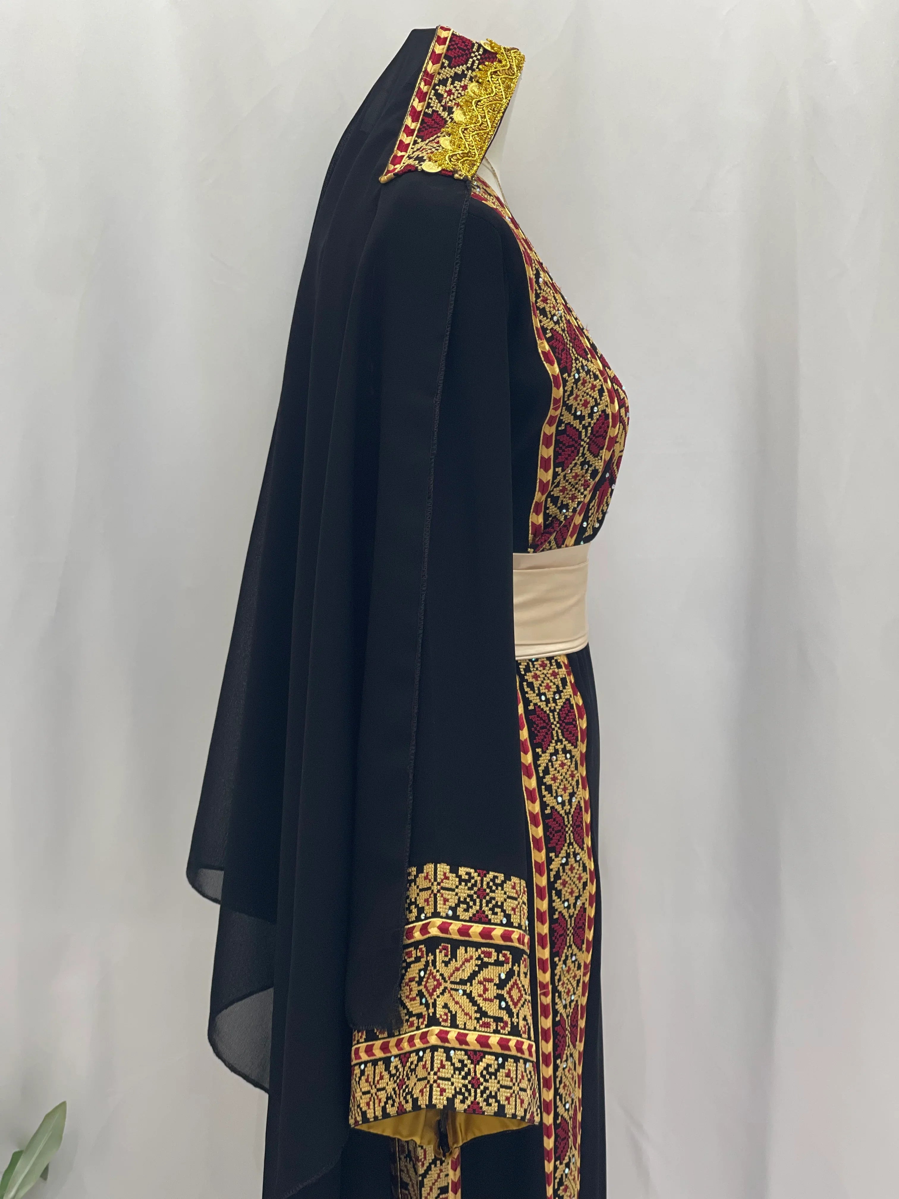 Palestinian embroidered thoub by Palestinian Elegance featuring black fabric with gold embroidery and a matching headscarf