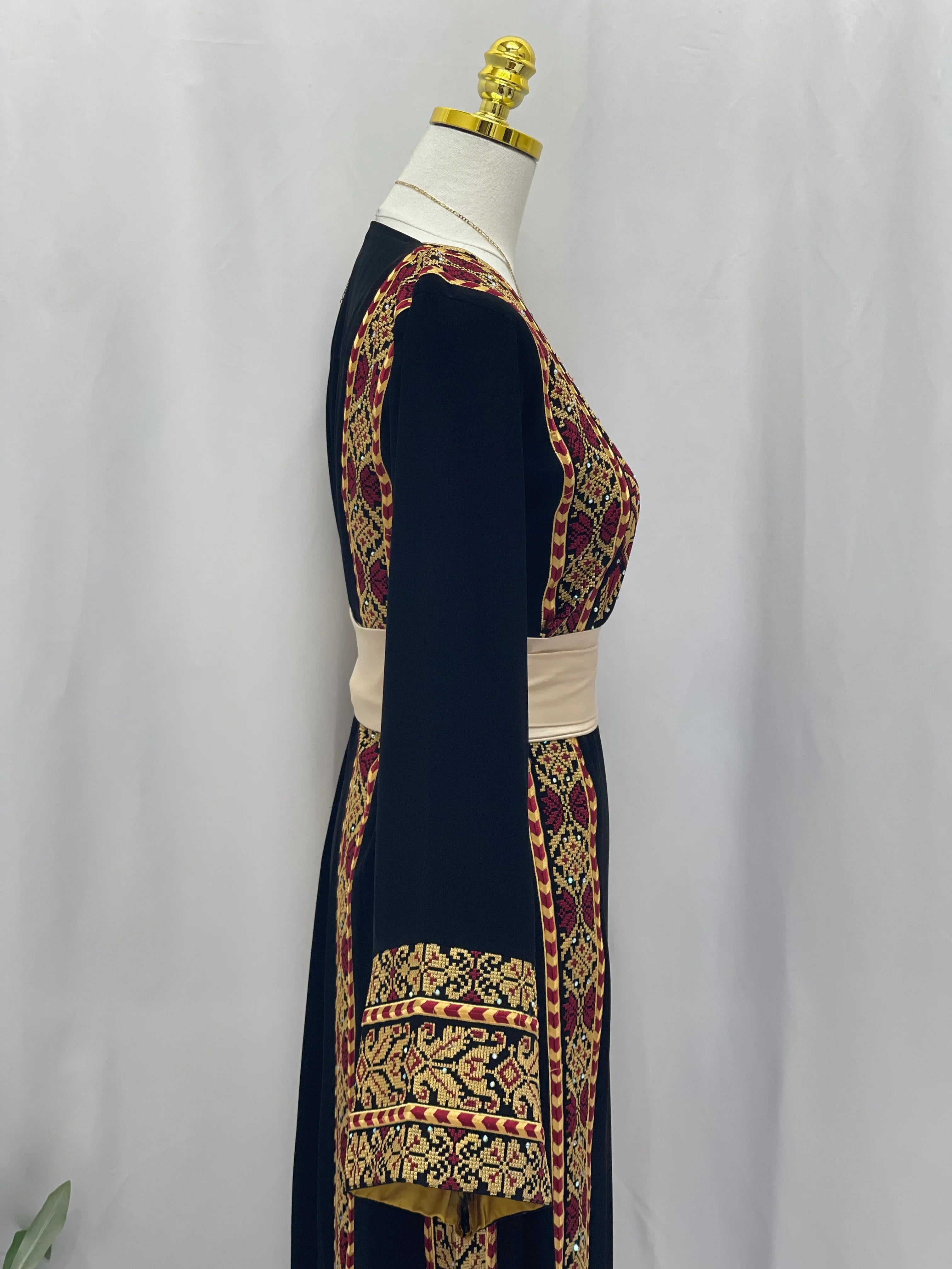 Palestinian embroidered thoub by Palestinian Elegance with intricate gold and red embroidery on black fabric