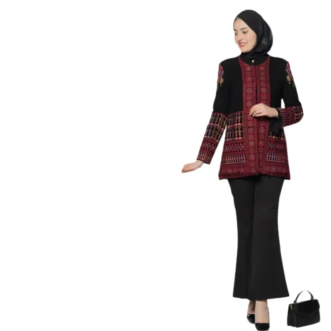 Woman wearing a black and red Palestinian embroidery jacket with intricate designs paired with black pants and a black hijab