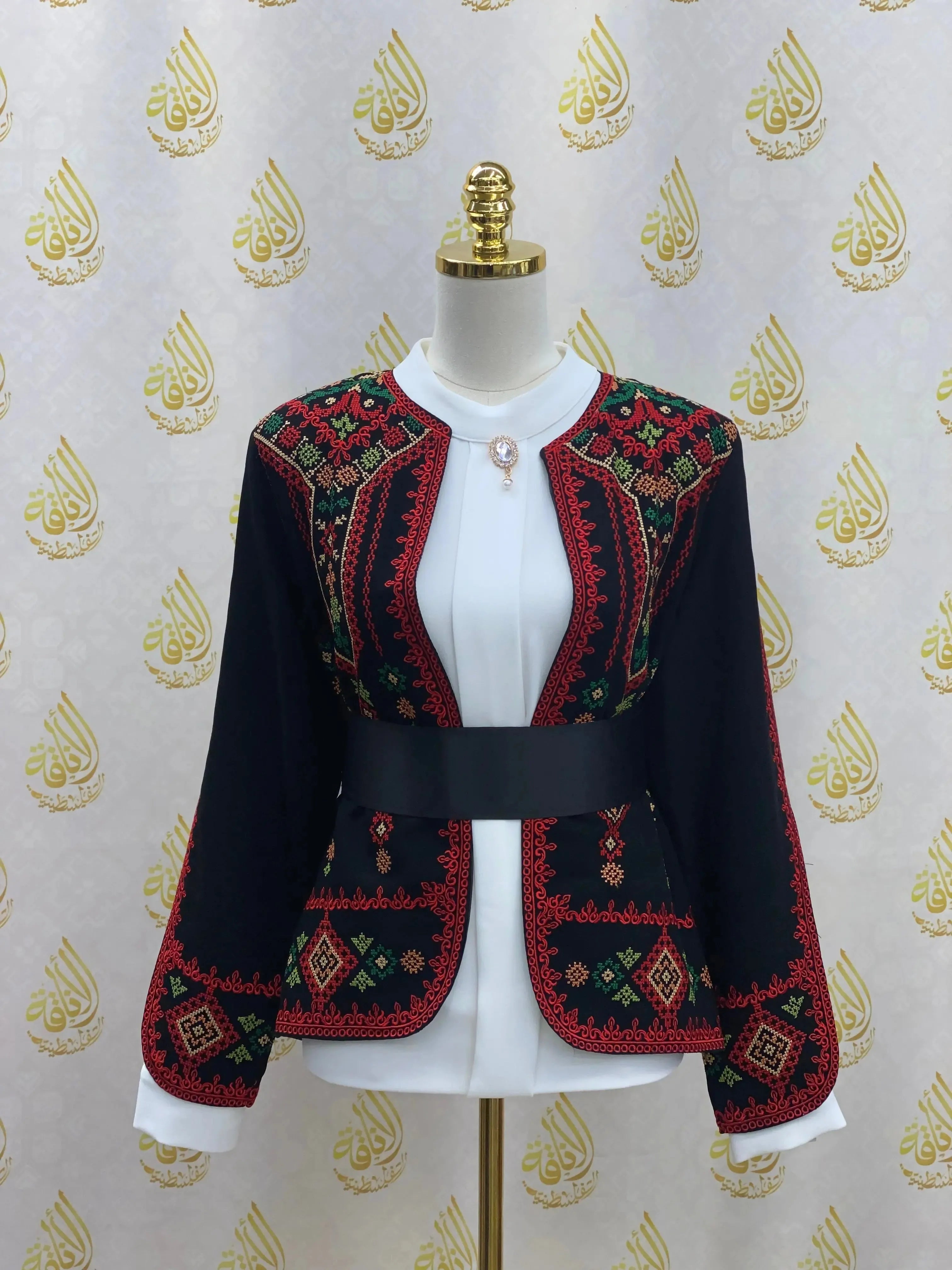 Traditional Palestinian jacket with intricate red and green embroidery on black fabric from Palestinian Elegance