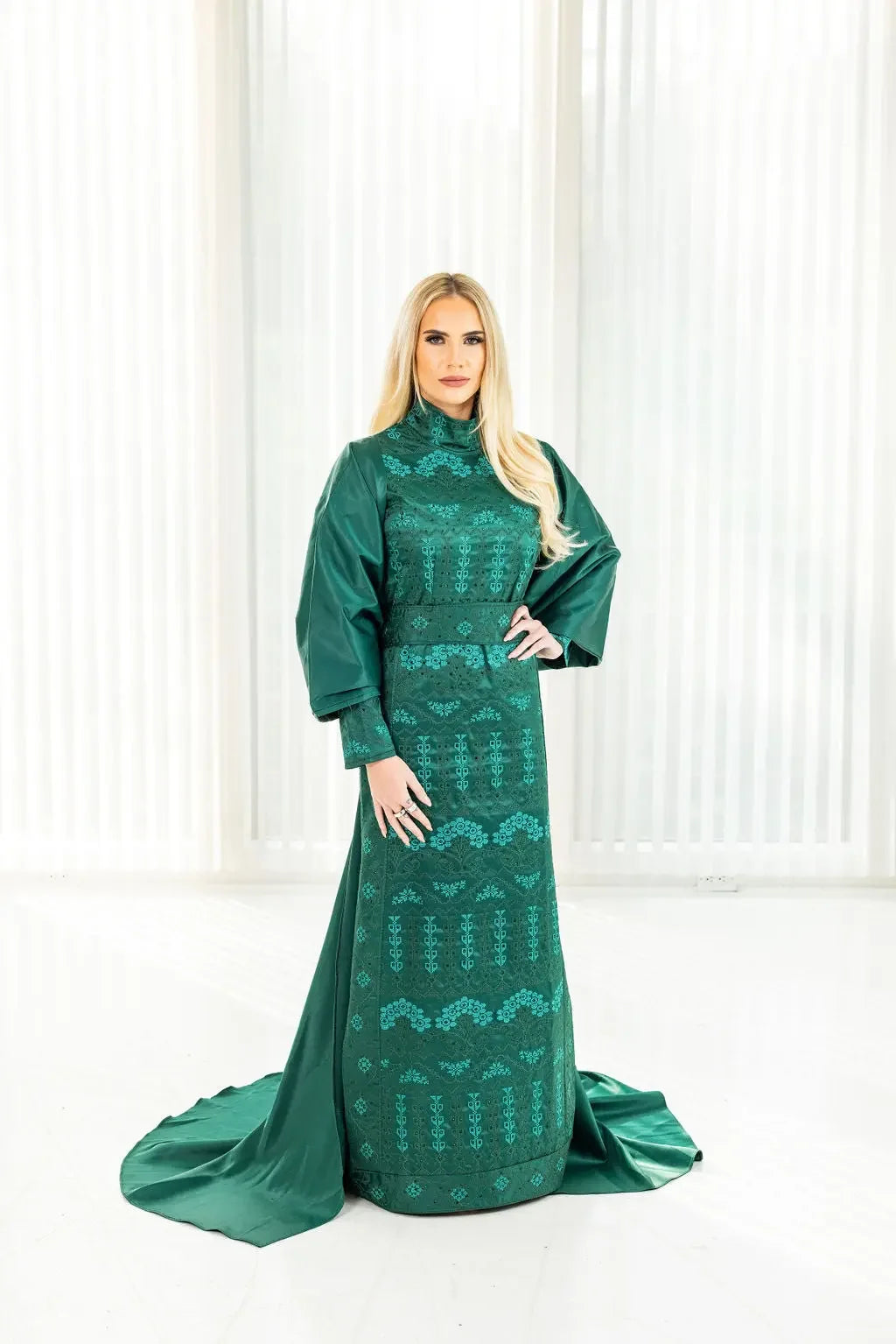 Green embroidered satin bridal dress with cape by Palestinian Elegance on model