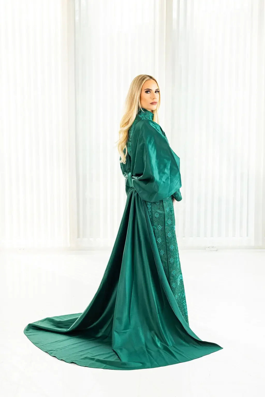 Emerald green satin bridal dress with cape featuring intricate Palestinian Elegance embroideries