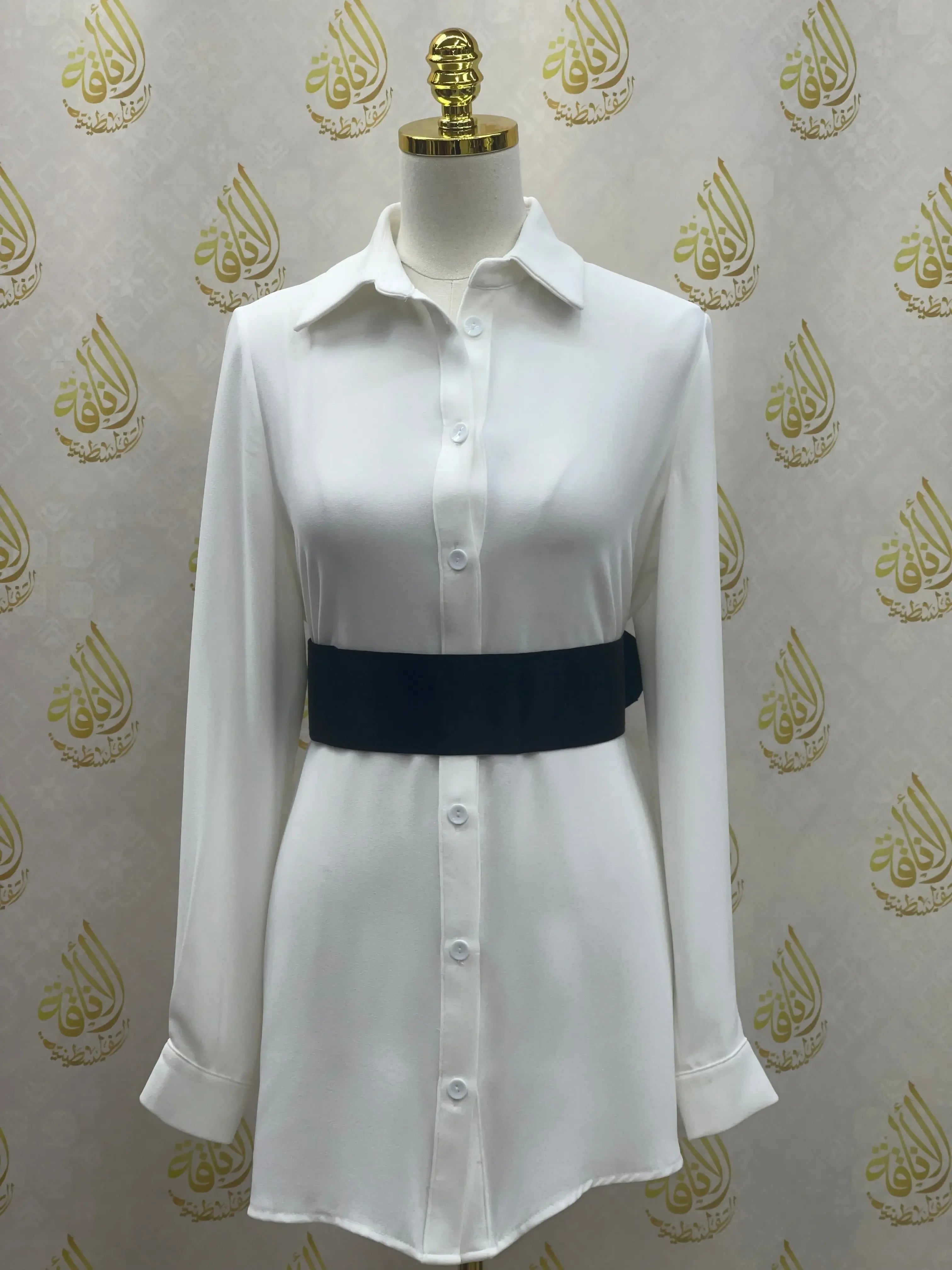 Palestinian Elegance white shirt dress styled with a black satin waist belt accessory