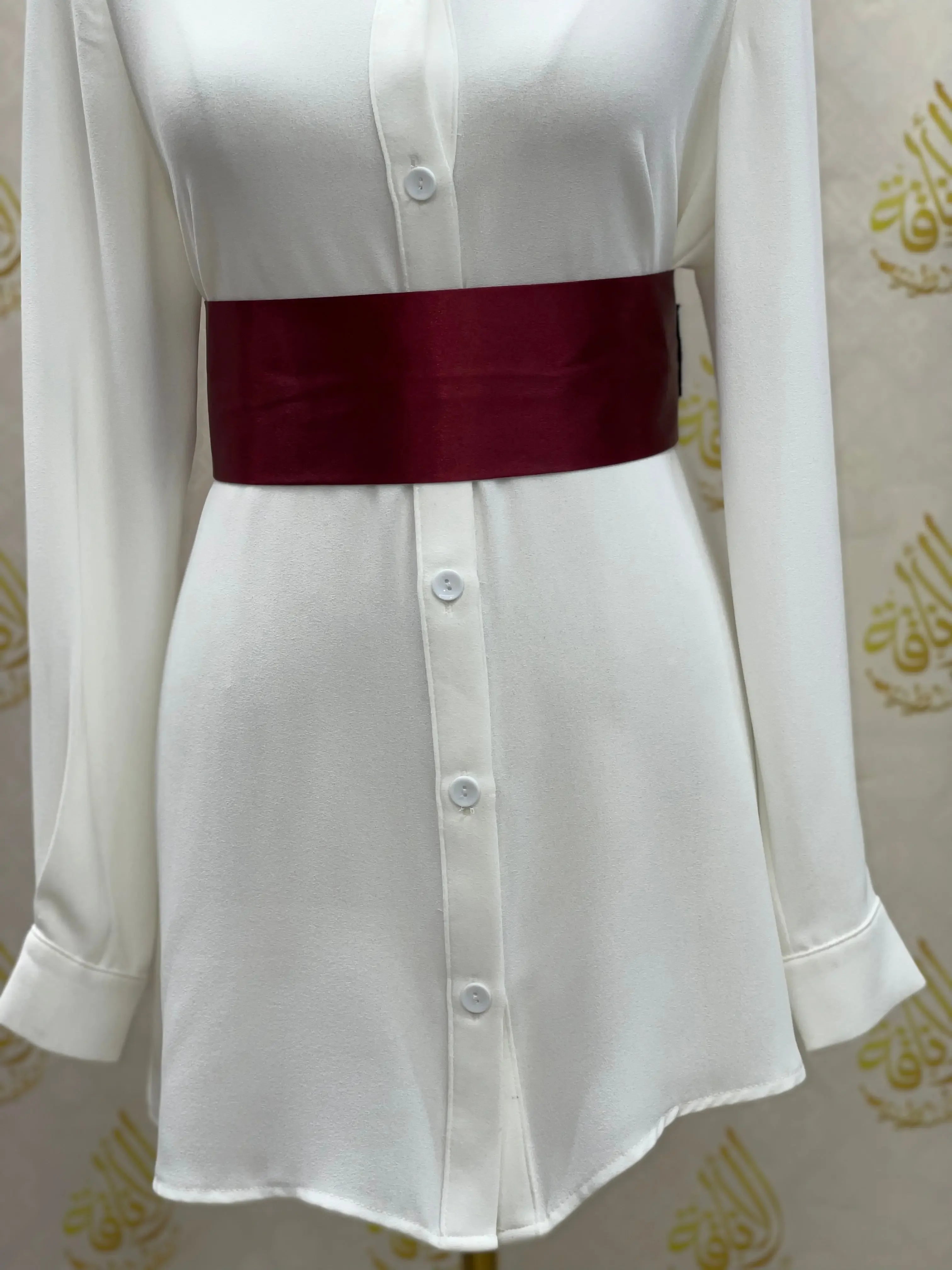 Palestinian Elegance satin waist belt in deep burgundy wrapped around white button-down dress
