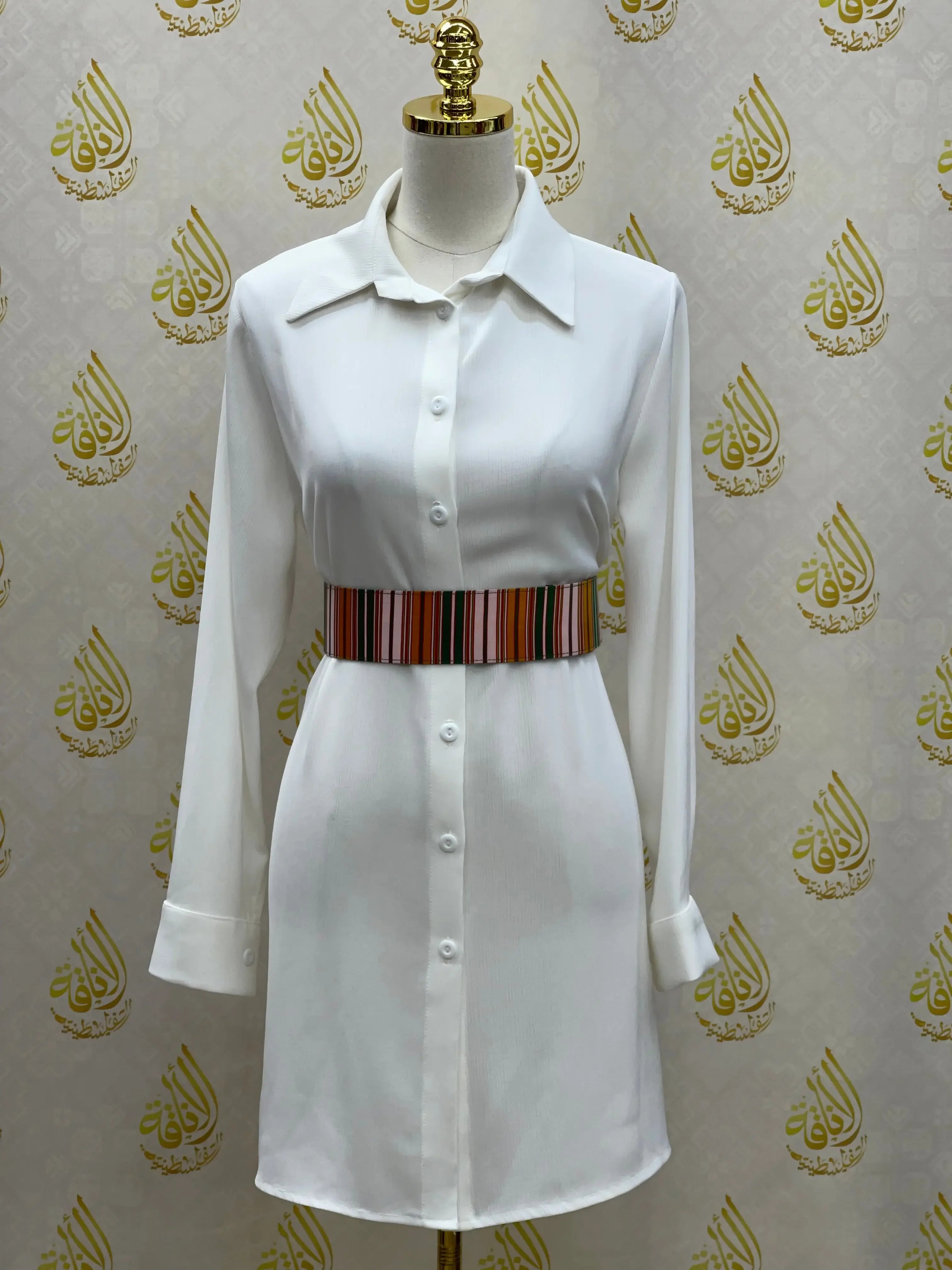 White shirt dress styled with a Palestinian Elegance satin waist belt featuring multicolor stripes