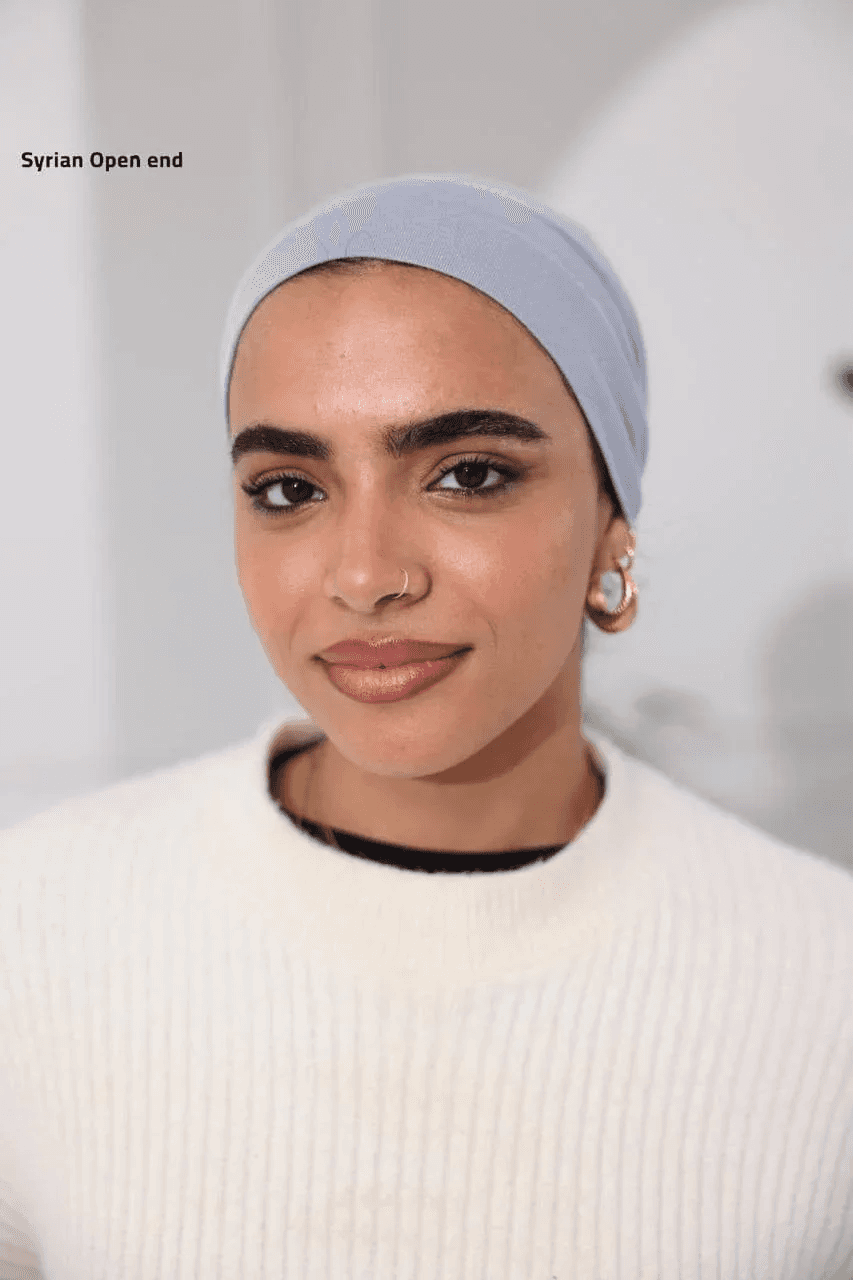 Woman wearing light blue Syrian-Style Open Bonnet headwear by Palestinian Elegance with hoop earrings