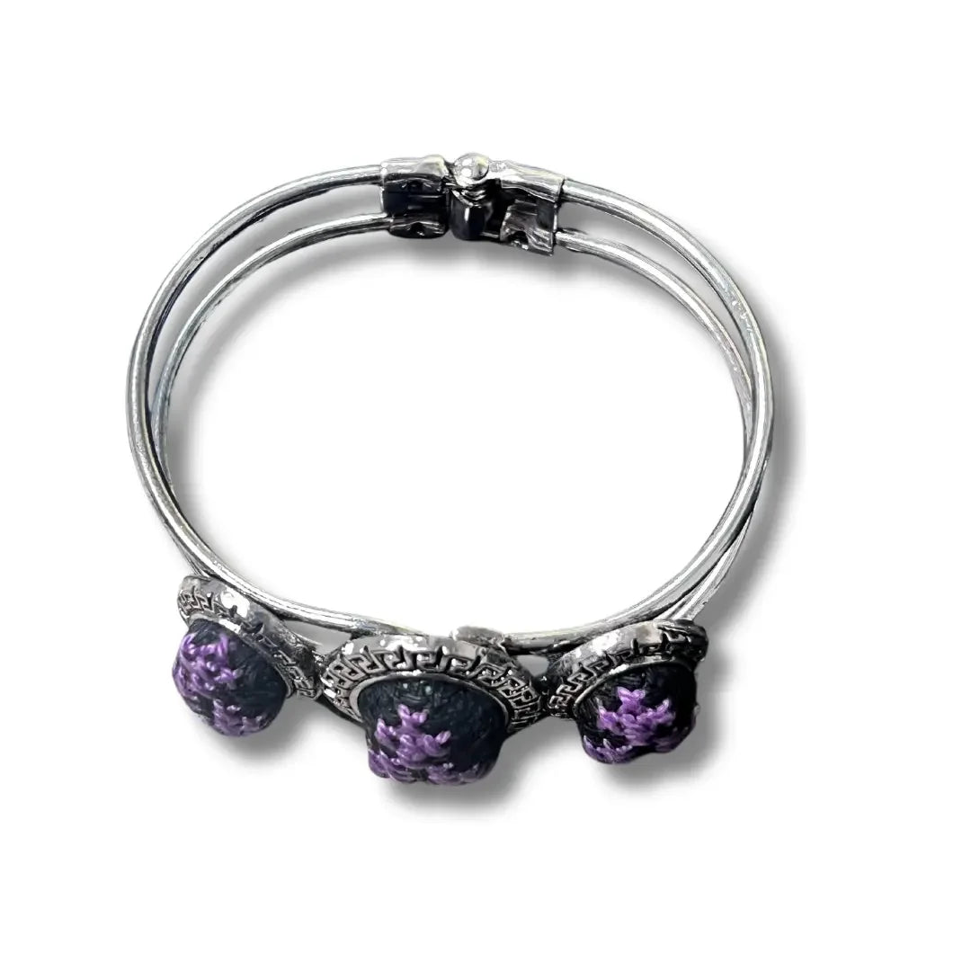 Palestinian Elegance tatreez silver bracelet with intricate purple embroidery details on three ornaments